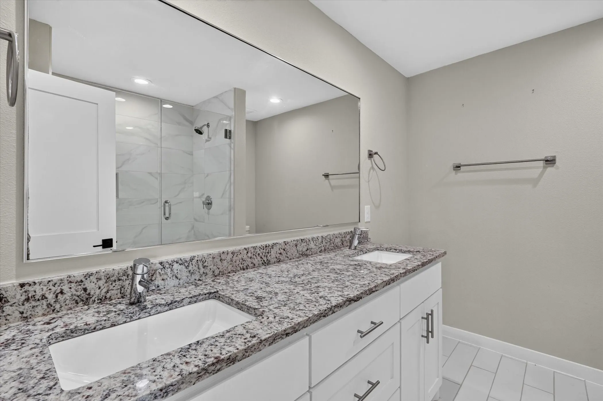 Dual vanity with white cabinetry, granite countertop, and integrated sinks