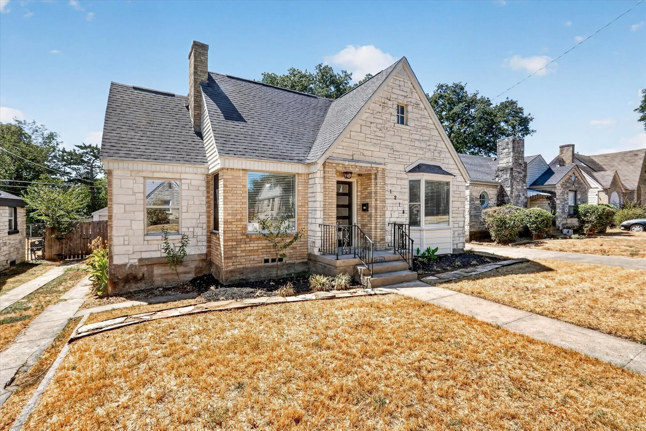 Stonework and brick veneer exterior with a gabled roofline and prominent chimney