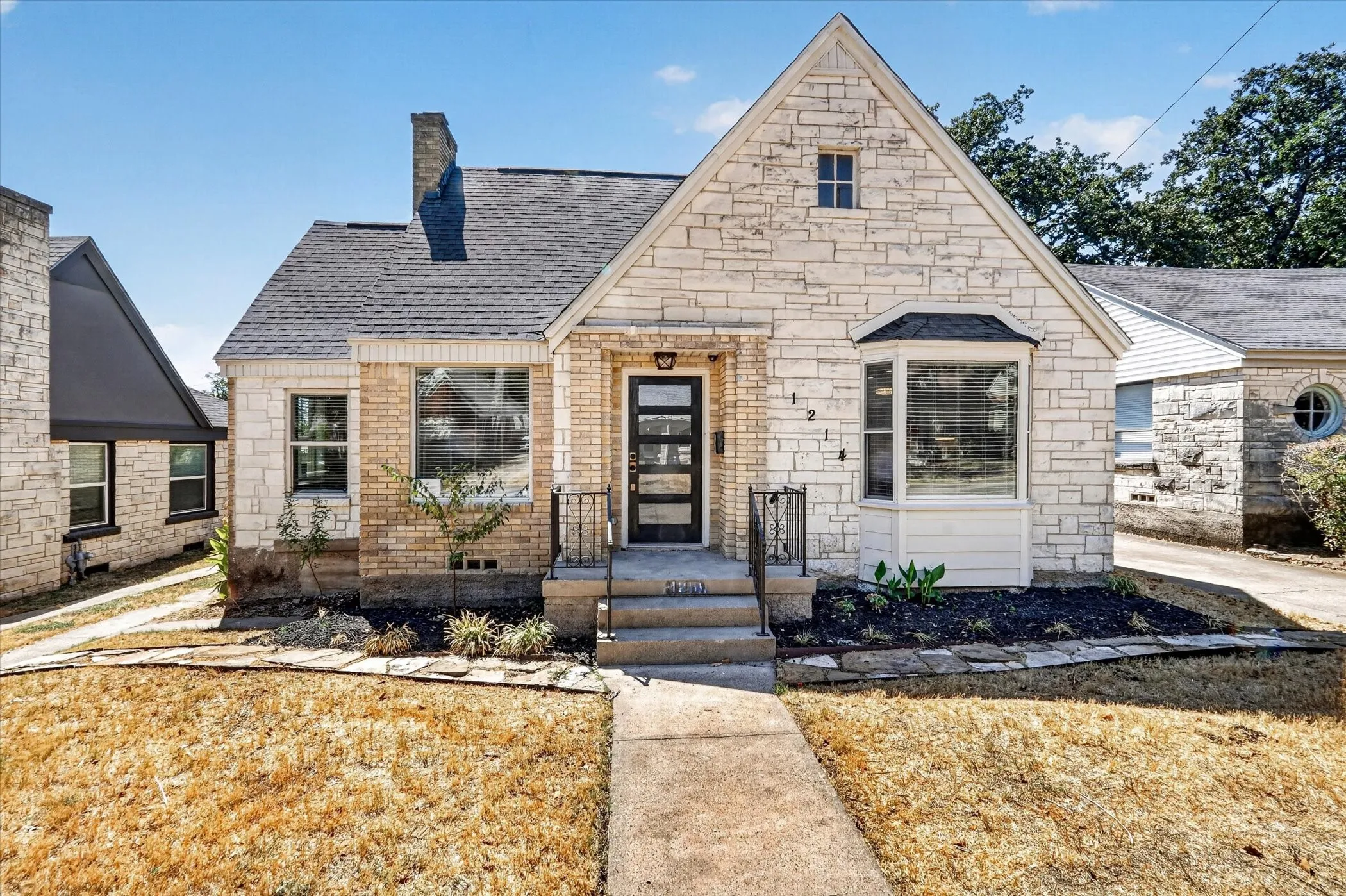 Stone and brick facade with an asphalt shingle roof