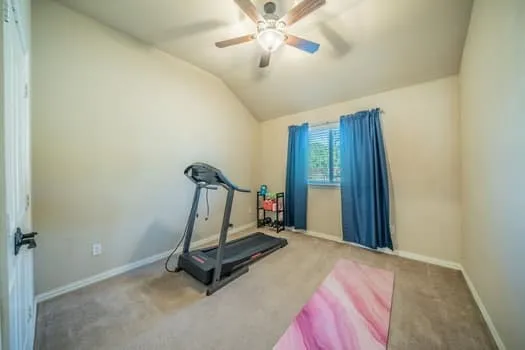 Vaulted ceiling with a ceiling fan, carpeted flooring, and a single window with blinds