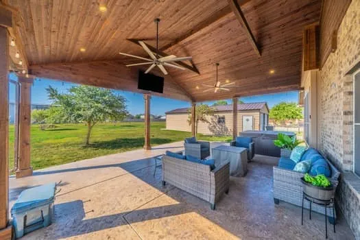 Covered patio with a wood-finish vaulted ceiling, recessed lighting, and ceiling fans