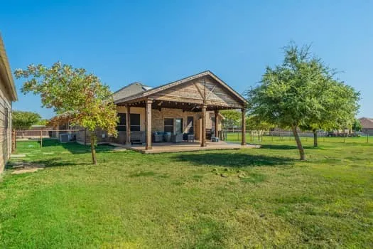 Expansive backyard featuring a manicured lawn, mature trees, and a covered patio with a wood-finish ceiling and wood columns, vaulted ceiling, huge for those outdoor gatherings, remember the hot tub to enjoy relaxation