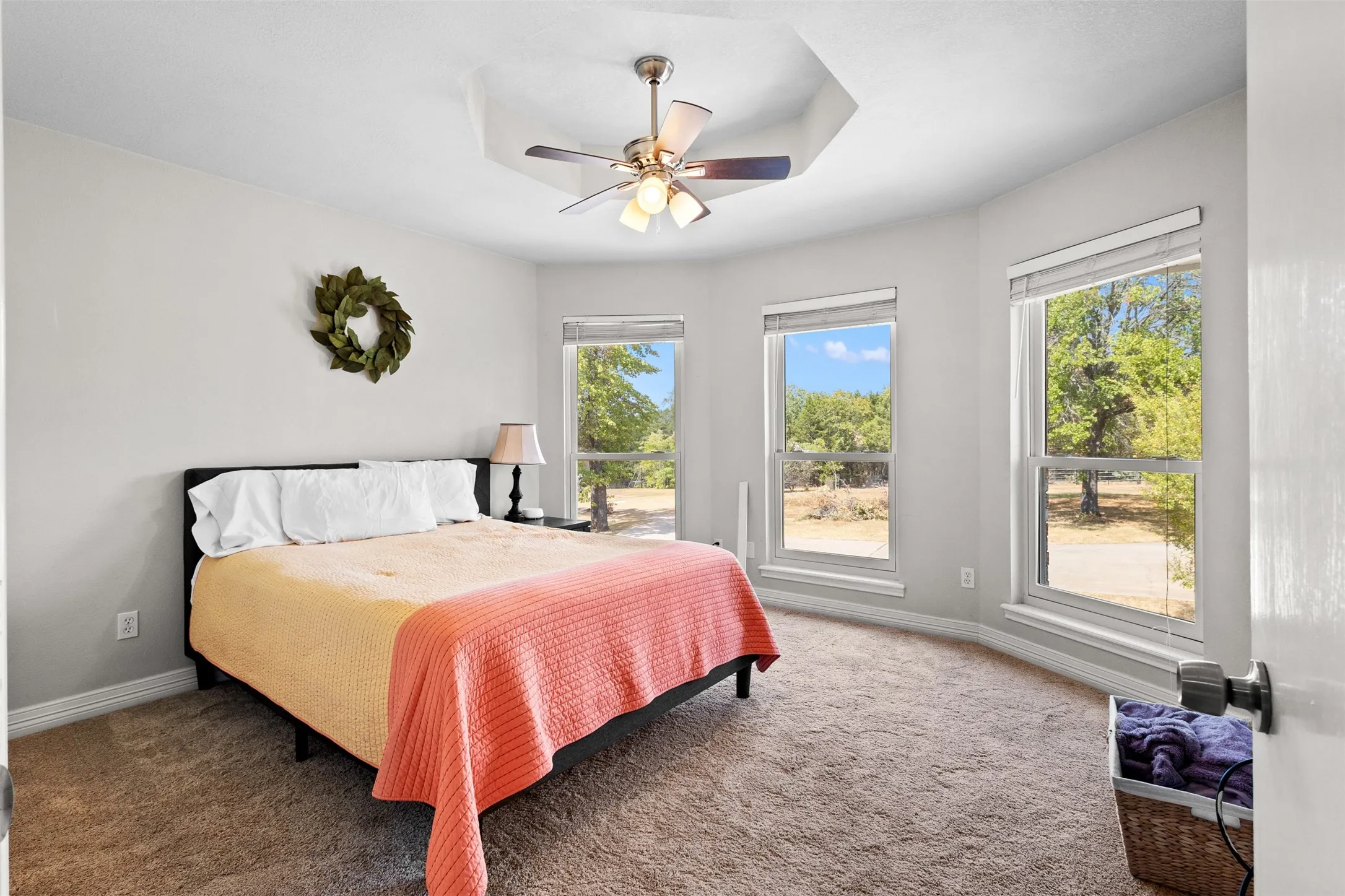 Upstairs bedroom with carpeted flooring, and multiple large windows with blinds