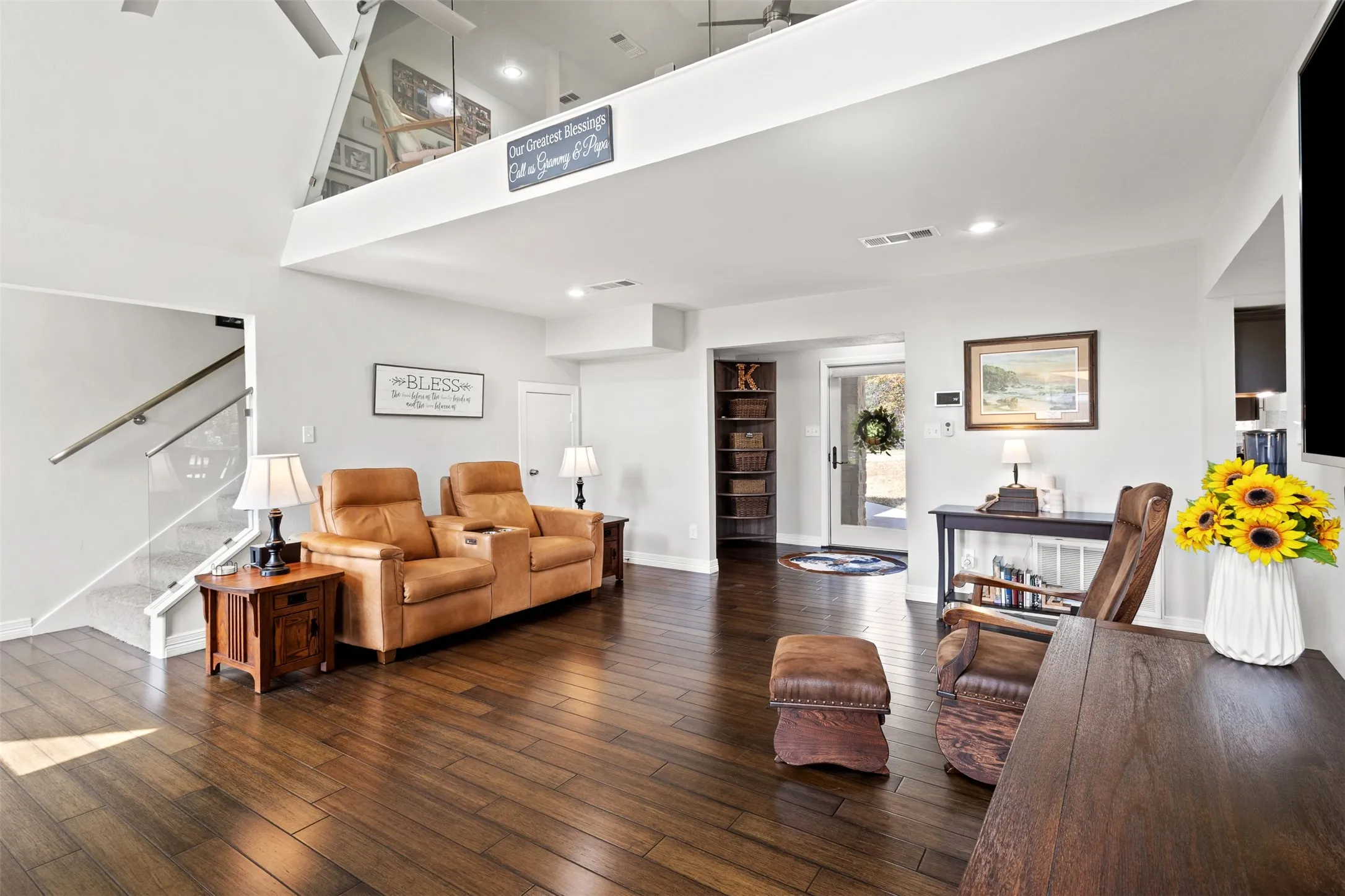 Vaulted ceiling, wood-finish flooring, glass panel stairway, recessed lighting, and an open loft area