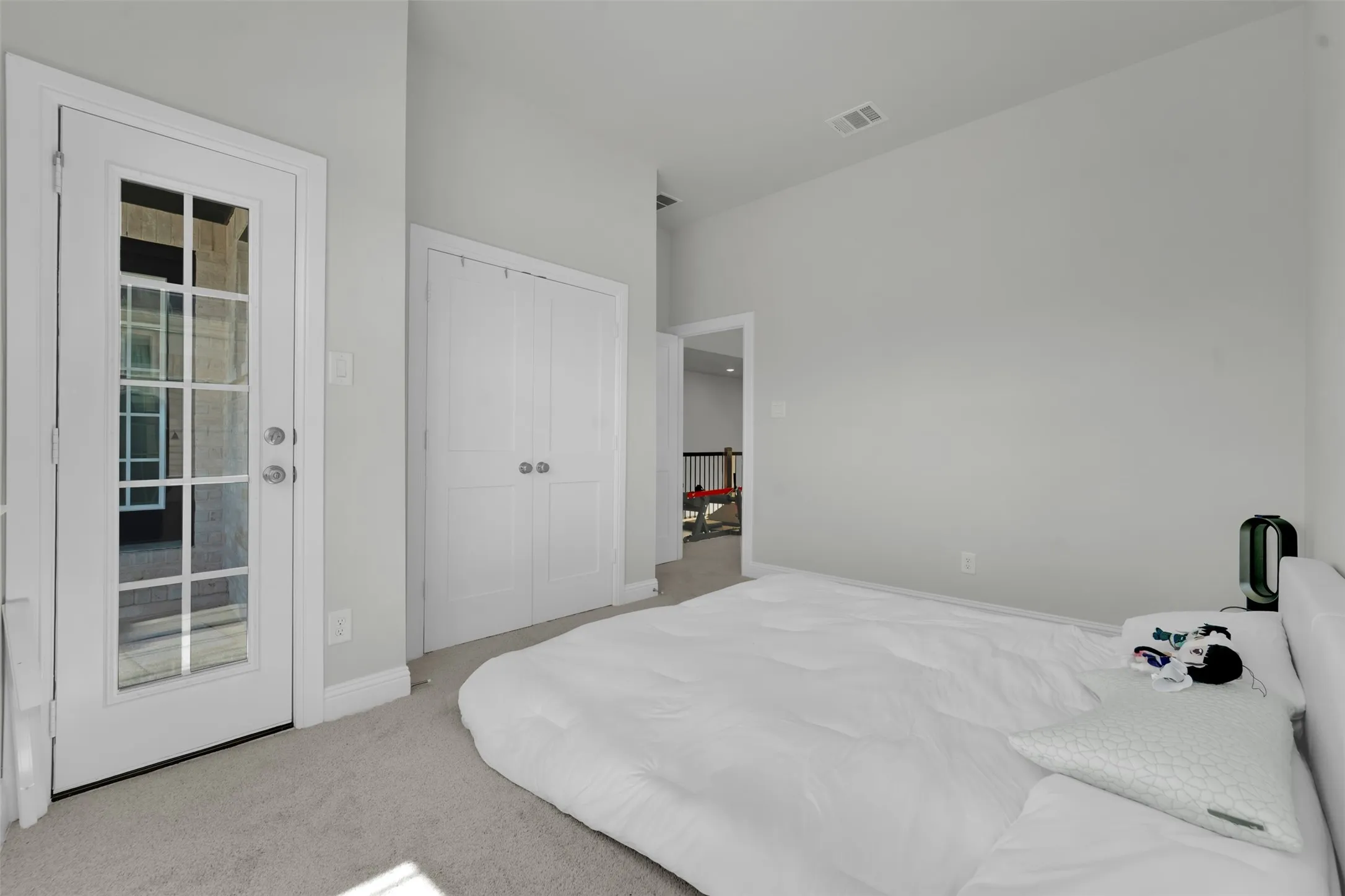 French door with multi-pane glass, white bi-fold closet doors, and light gray wall finish