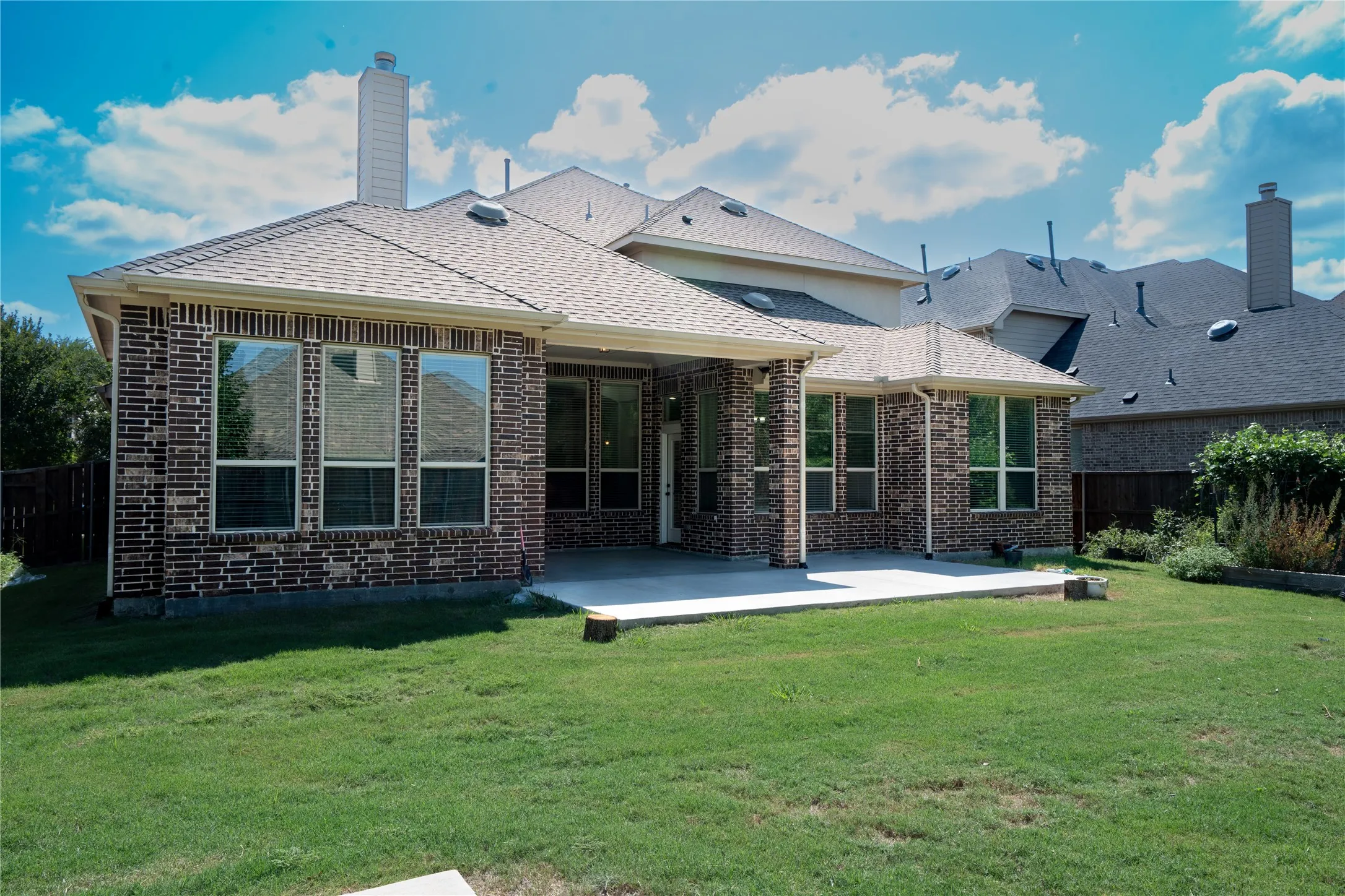 Brick exterior with a covered patio and an extended concrete pad