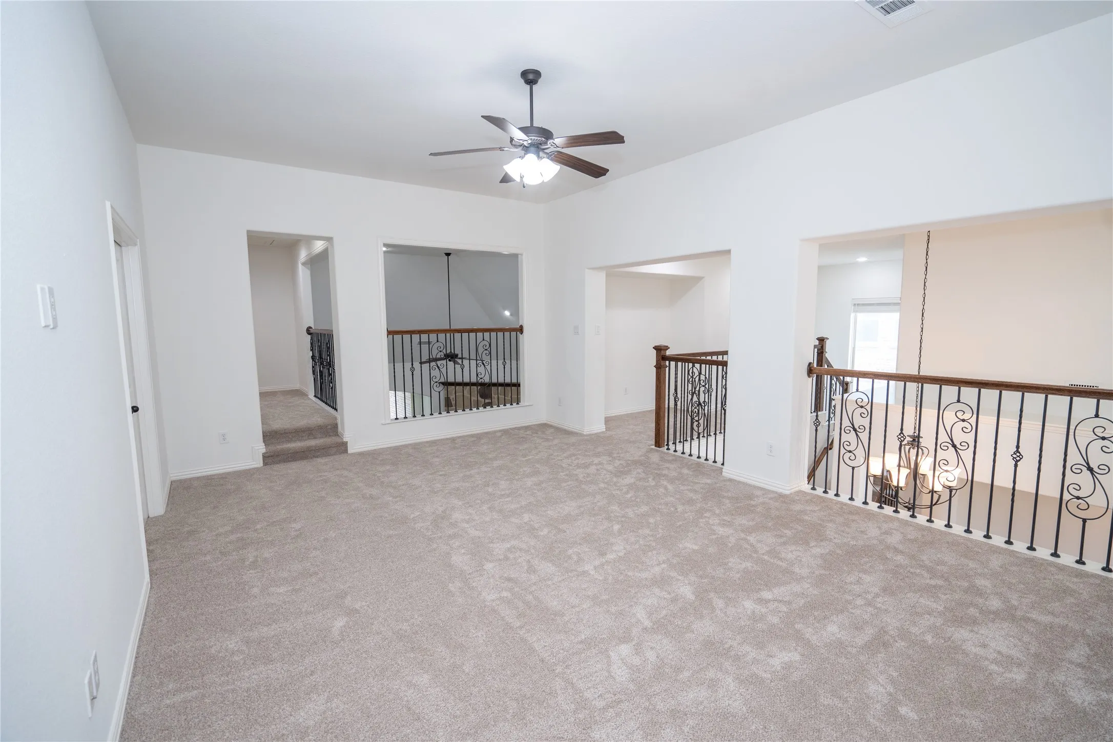 Carpeted open-concept bonus room with a ceiling fan