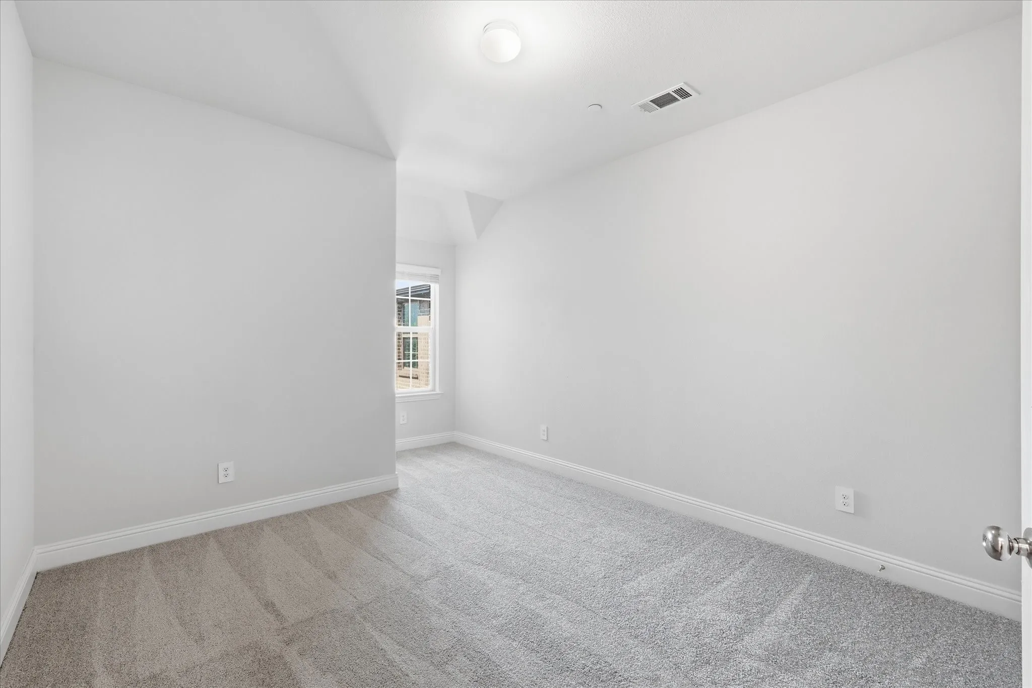 Neutral tone walls, recessed window, light gray carpeting, and overhead lighting
