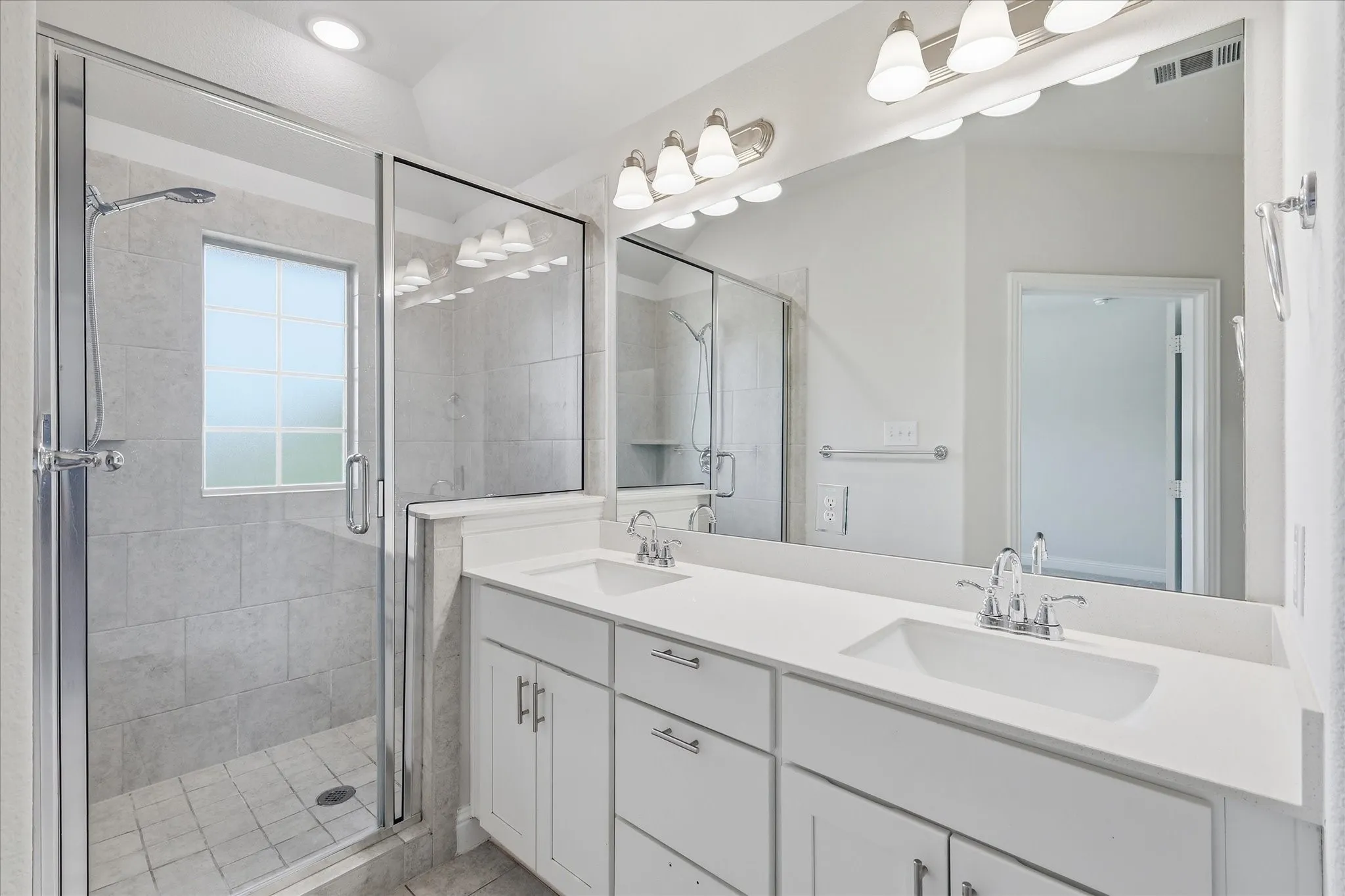 Dual vanity with white cabinetry, polished chrome fixtures, and integrated sinks