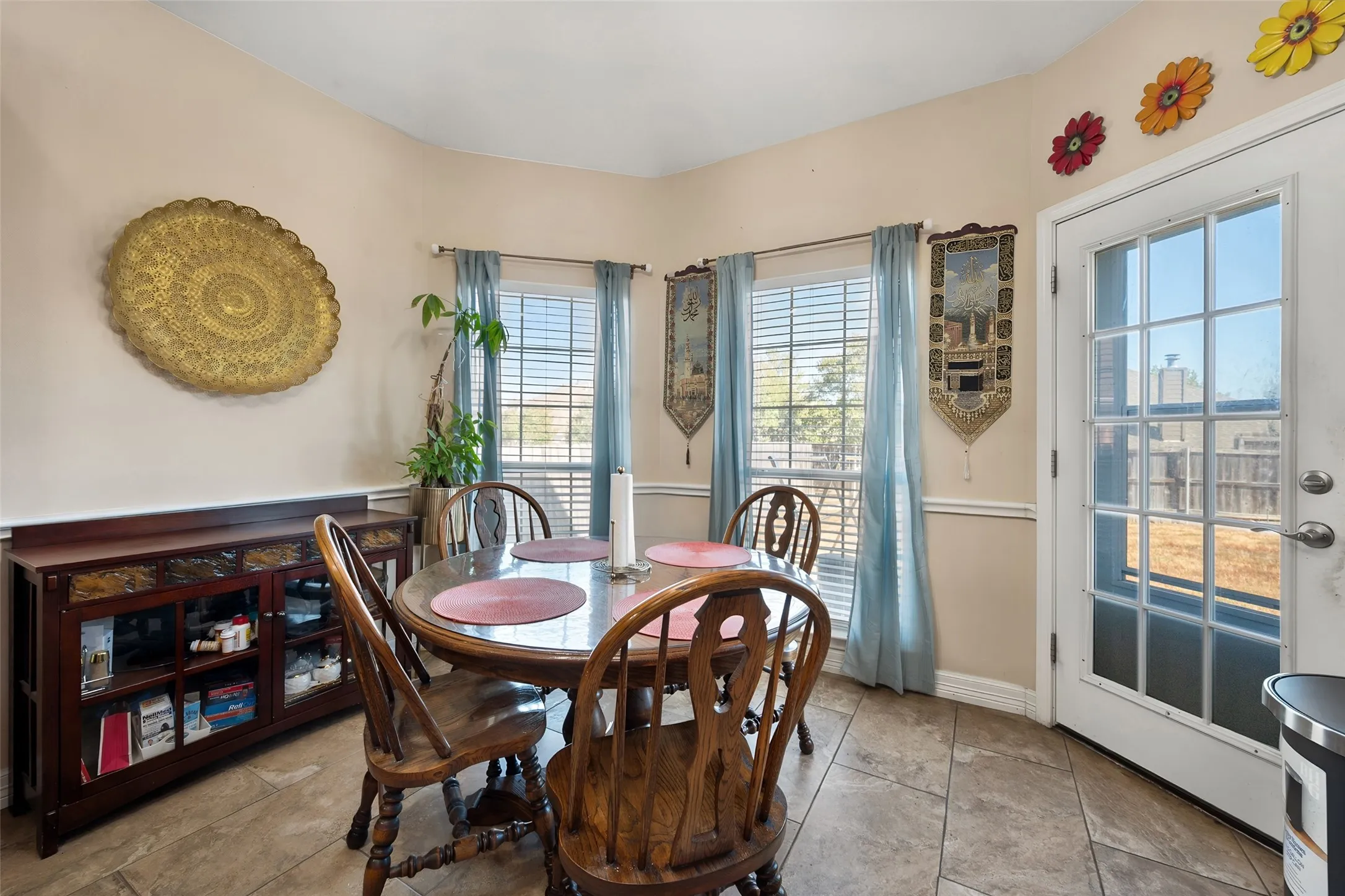 Eat-in kitchen area featuring tile flooring, dual-pane windows, and a glass-paneled exterior door leading to the back yard