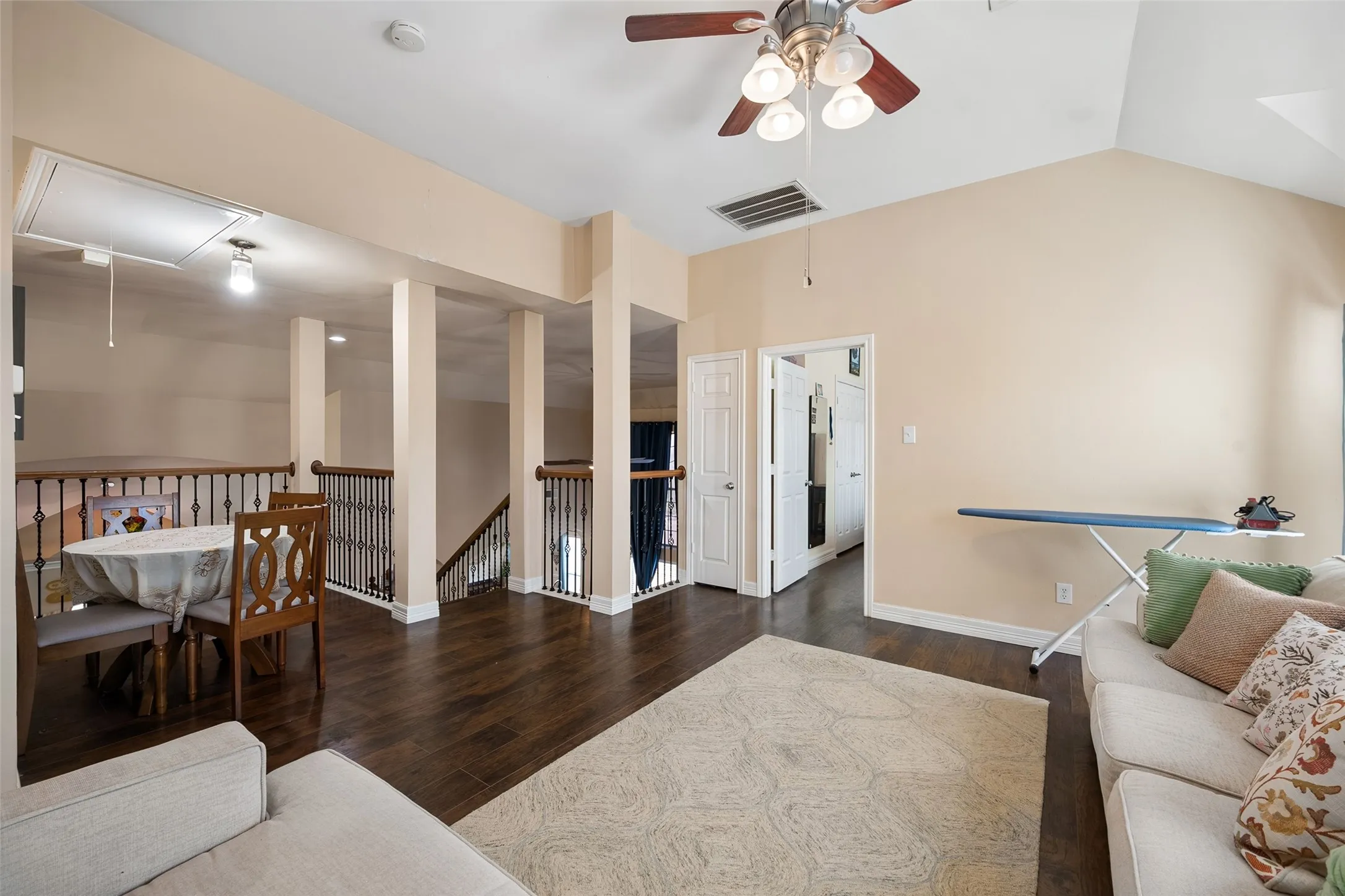Vaulted ceiling, wood-finish flooring, ceiling fan, and painted walls