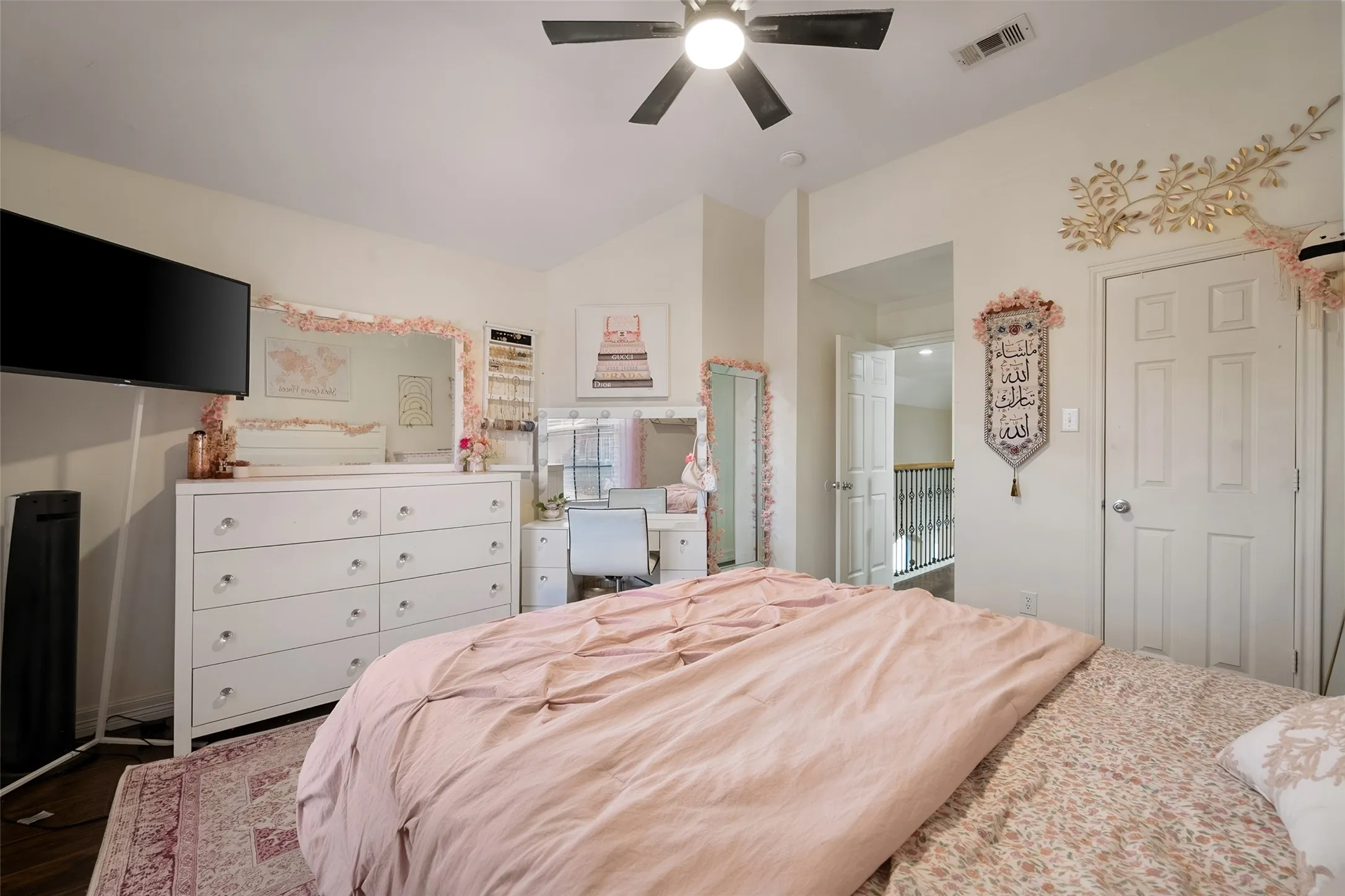 upstairs bedroom,Vaulted ceiling with an attached ceiling fan, panel doors, and a wood-finish floor