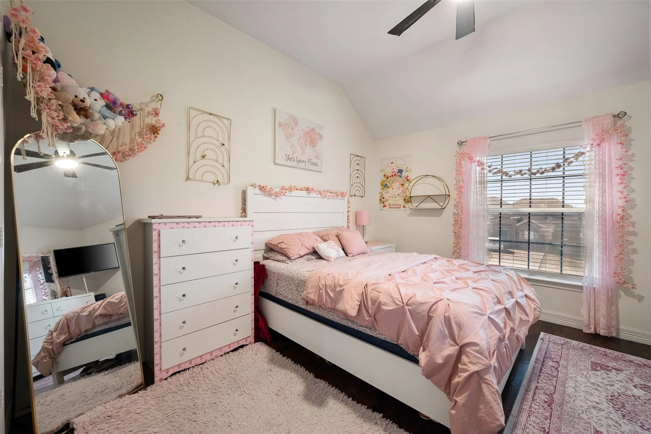 upstairs bedroom,Vaulted ceiling with a ceiling fan, window with blinds, wood-finish flooring, and white walls