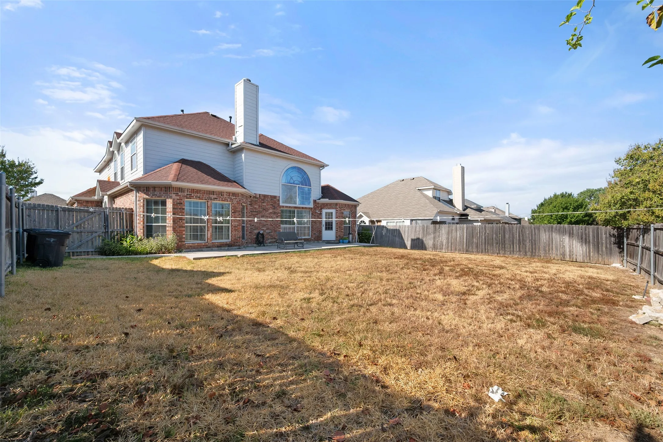 Expansive backyard with a full privacy fence, providing ample space