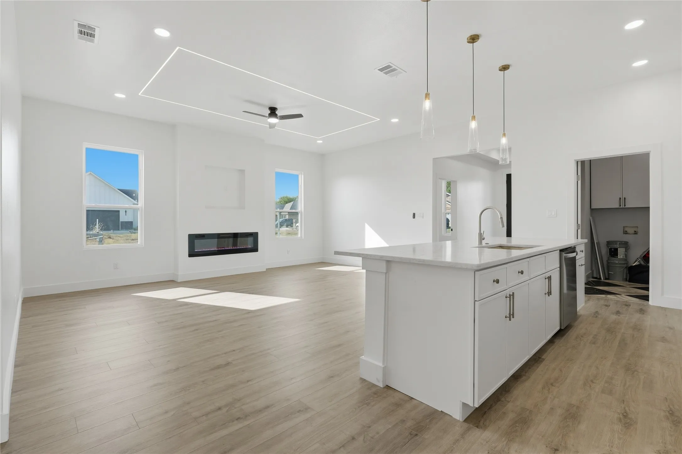 Spacious room featuring wood-finish flooring, a contemporary fireplace, and recessed lighting