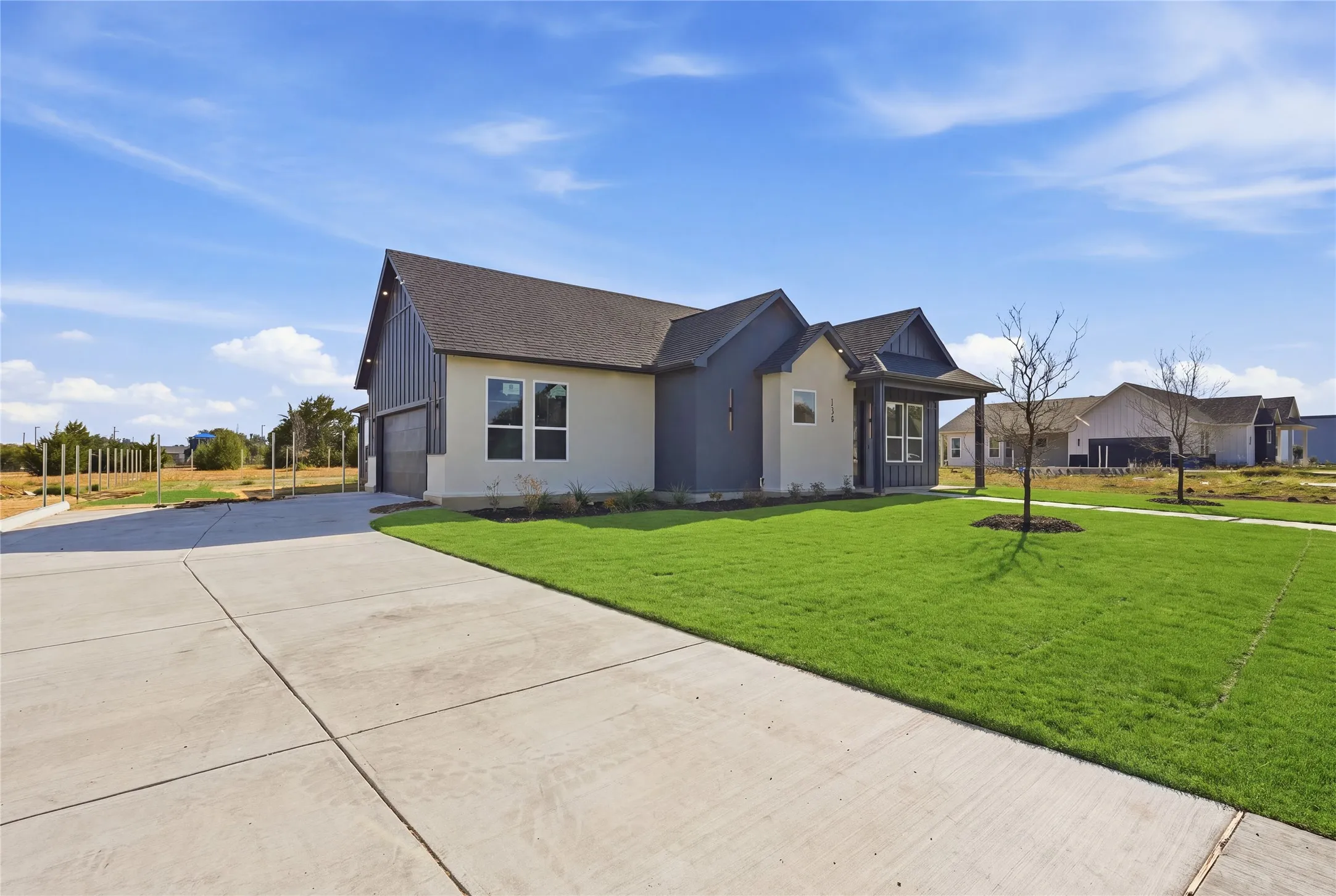 Modern farmhouse style exterior with a covered entry, attached two-car garage, and a concrete driveway
