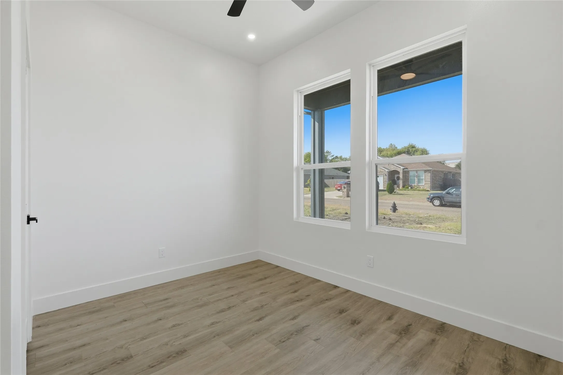 Recessed ceiling lighting, a ceiling fan, and wood-finish flooring
