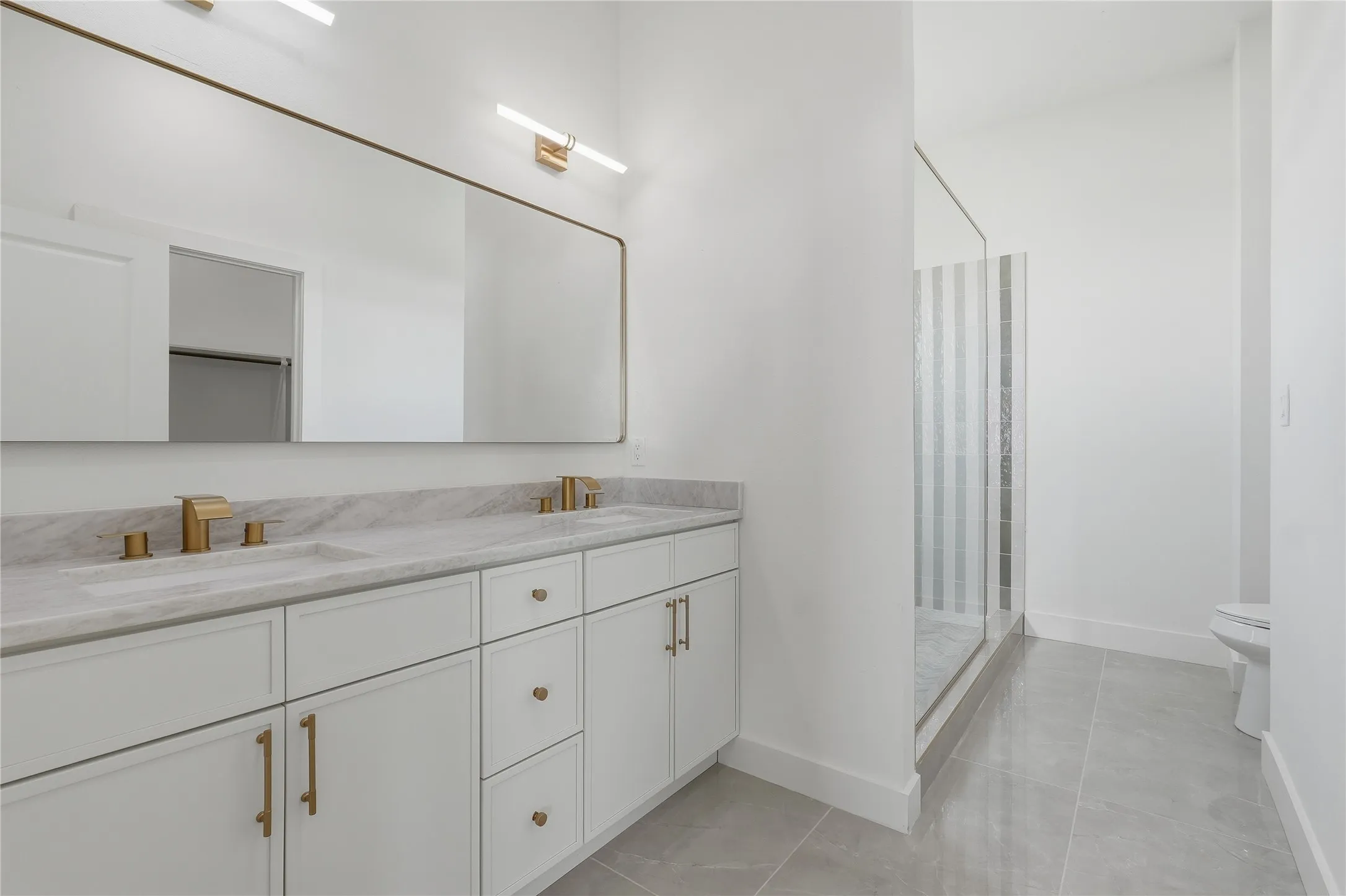 Dual vanity with brass fixtures and stone countertop