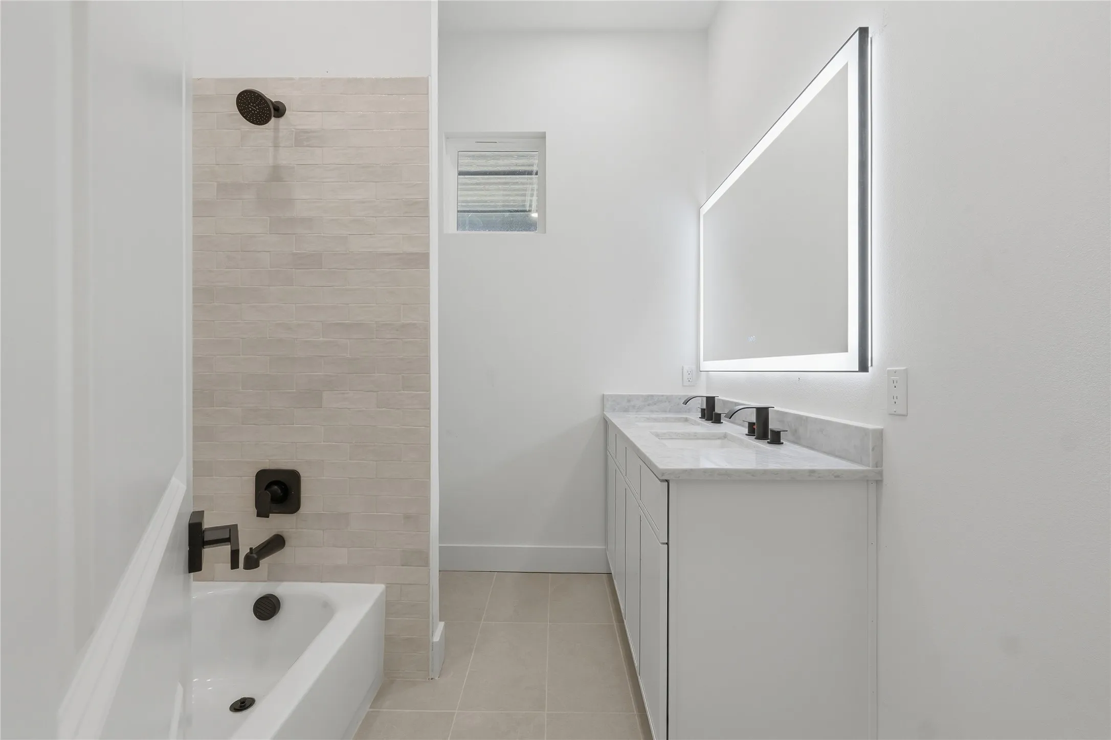 Dual vanity with integrated sinks, a built-in illuminated mirror, and a tile backsplash