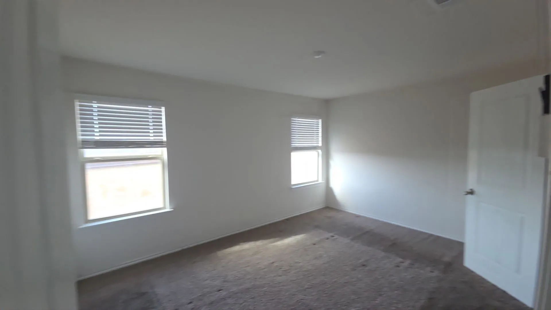 Neutral wall finishes, recessed lighting, and two windows with blinds