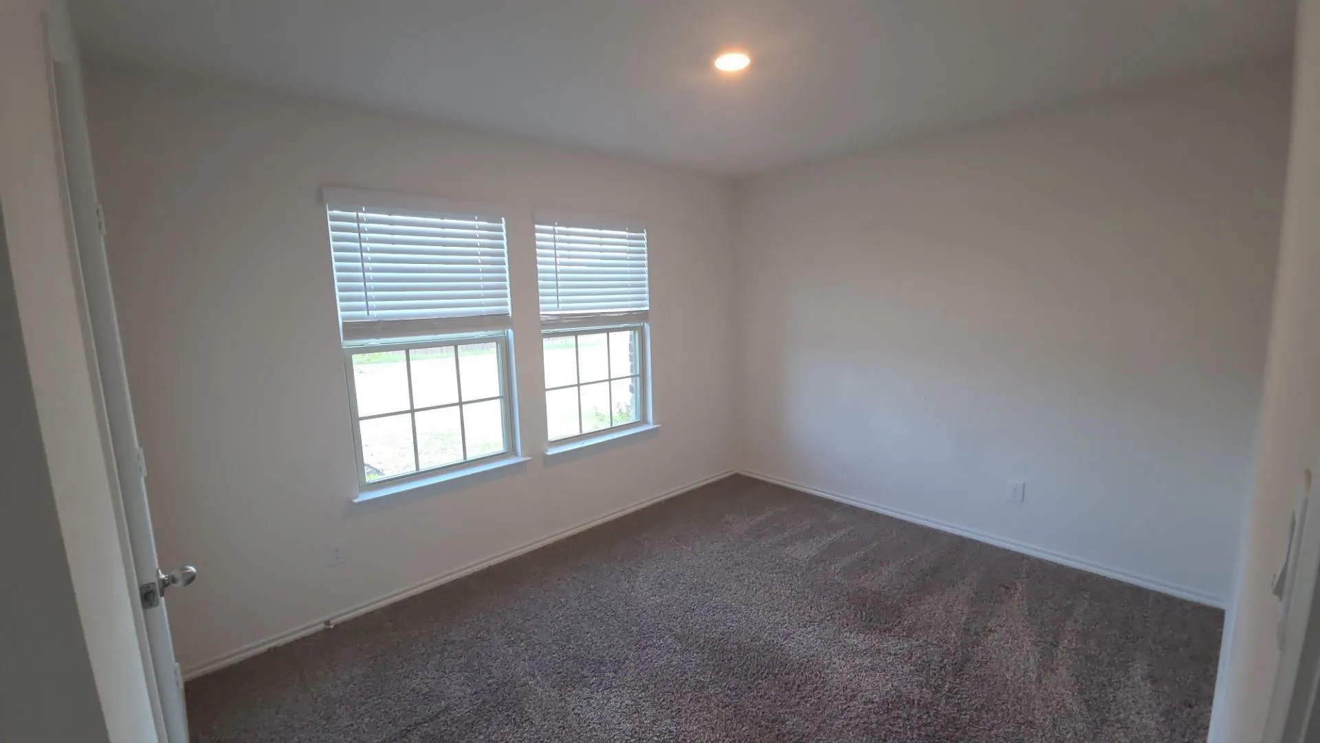 Neutral wall paint, recessed lighting, and carpeted flooring