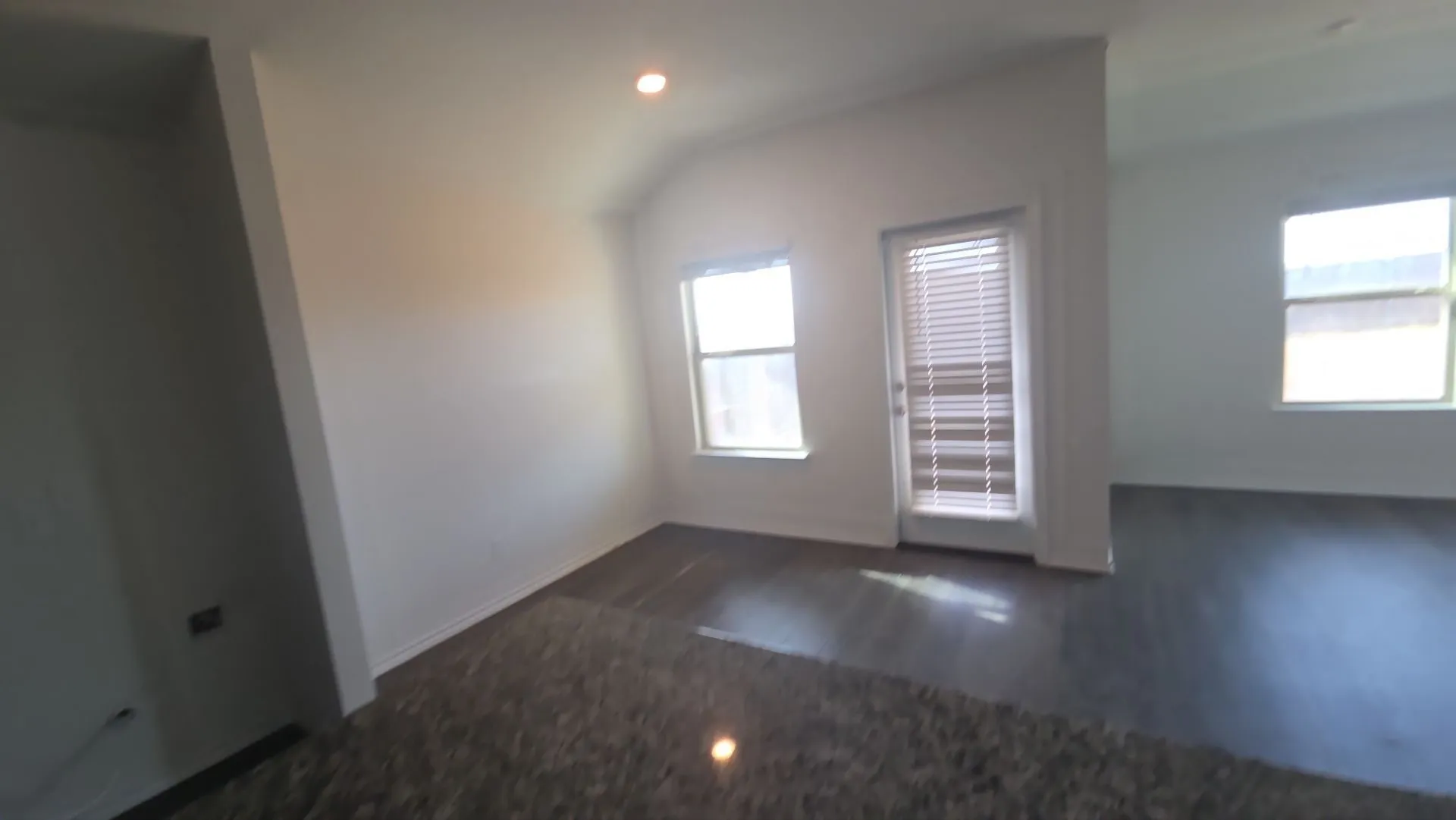 Recessed ceiling lighting, multiple windows with blinds, and wood-finish flooring