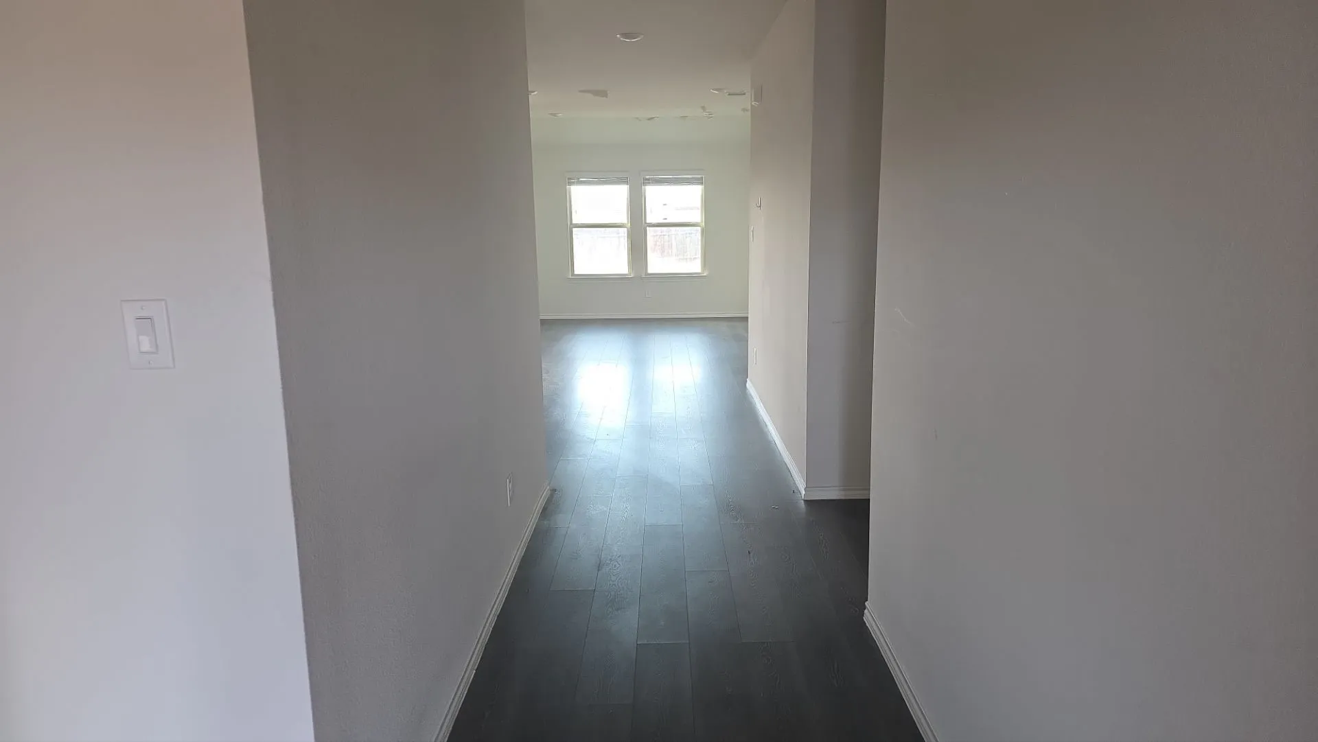 Wood-finish flooring throughout, recessed ceiling lighting, and multiple windows providing ambient light