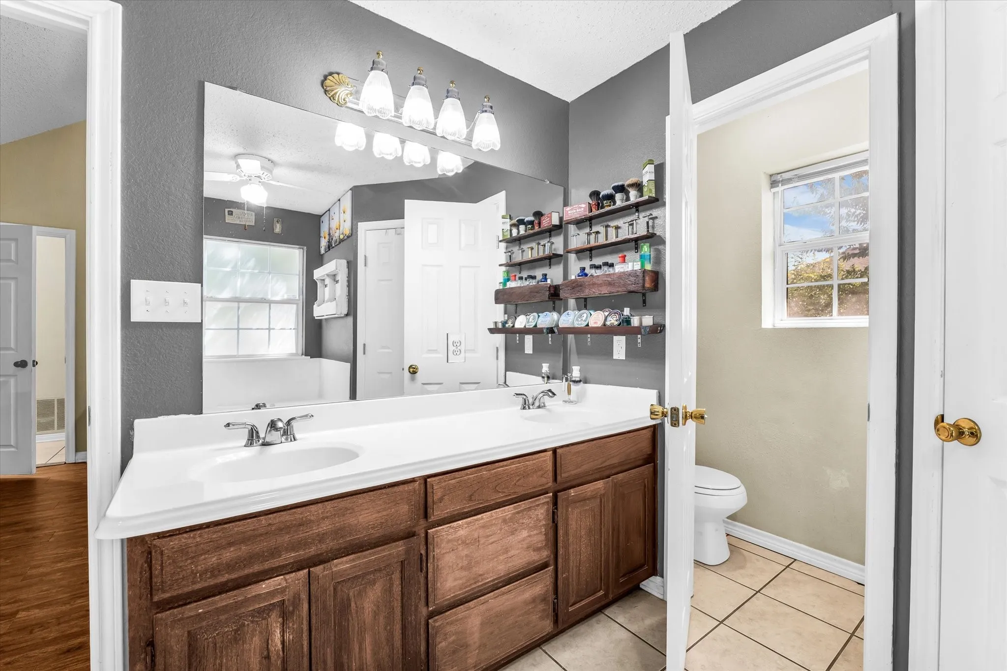 Double vanity with individual sinks, wood-finish cabinetry, and an integrated countertop