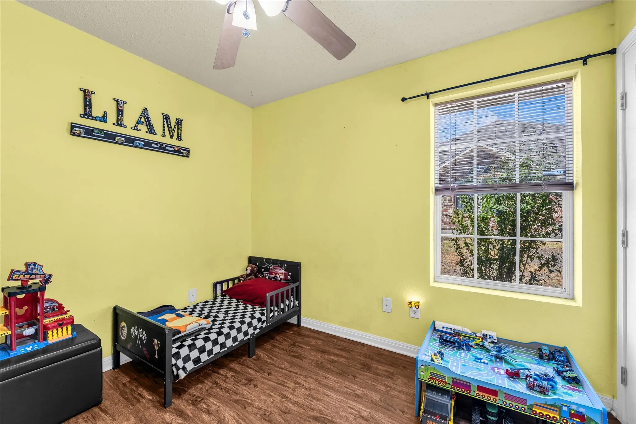 Wood-finish flooring, ceiling fan, and a window with blinds
