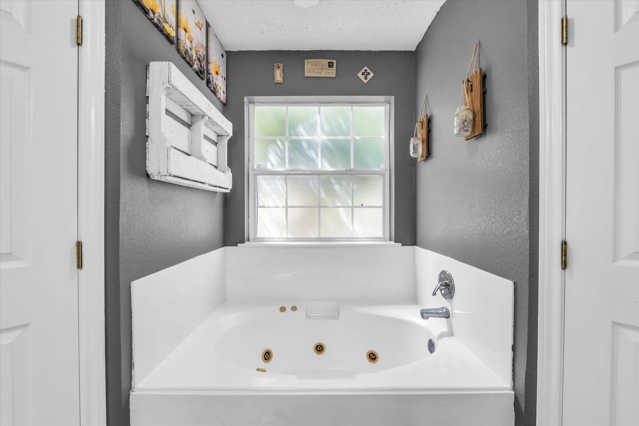 White soaking tub with integrated jets and chrome fixtures