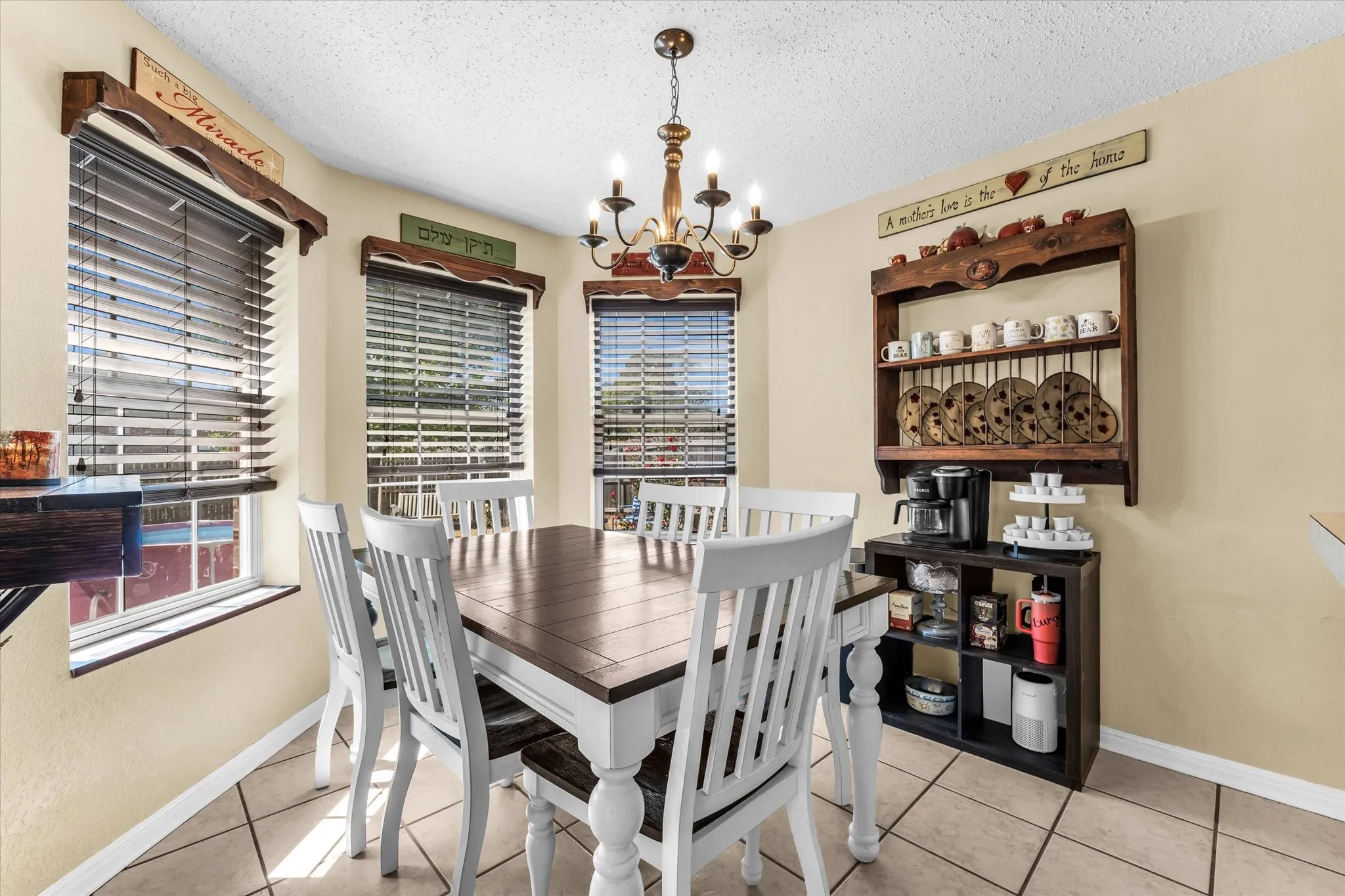Recessed bay window, tile flooring, and a multi-light chandelier