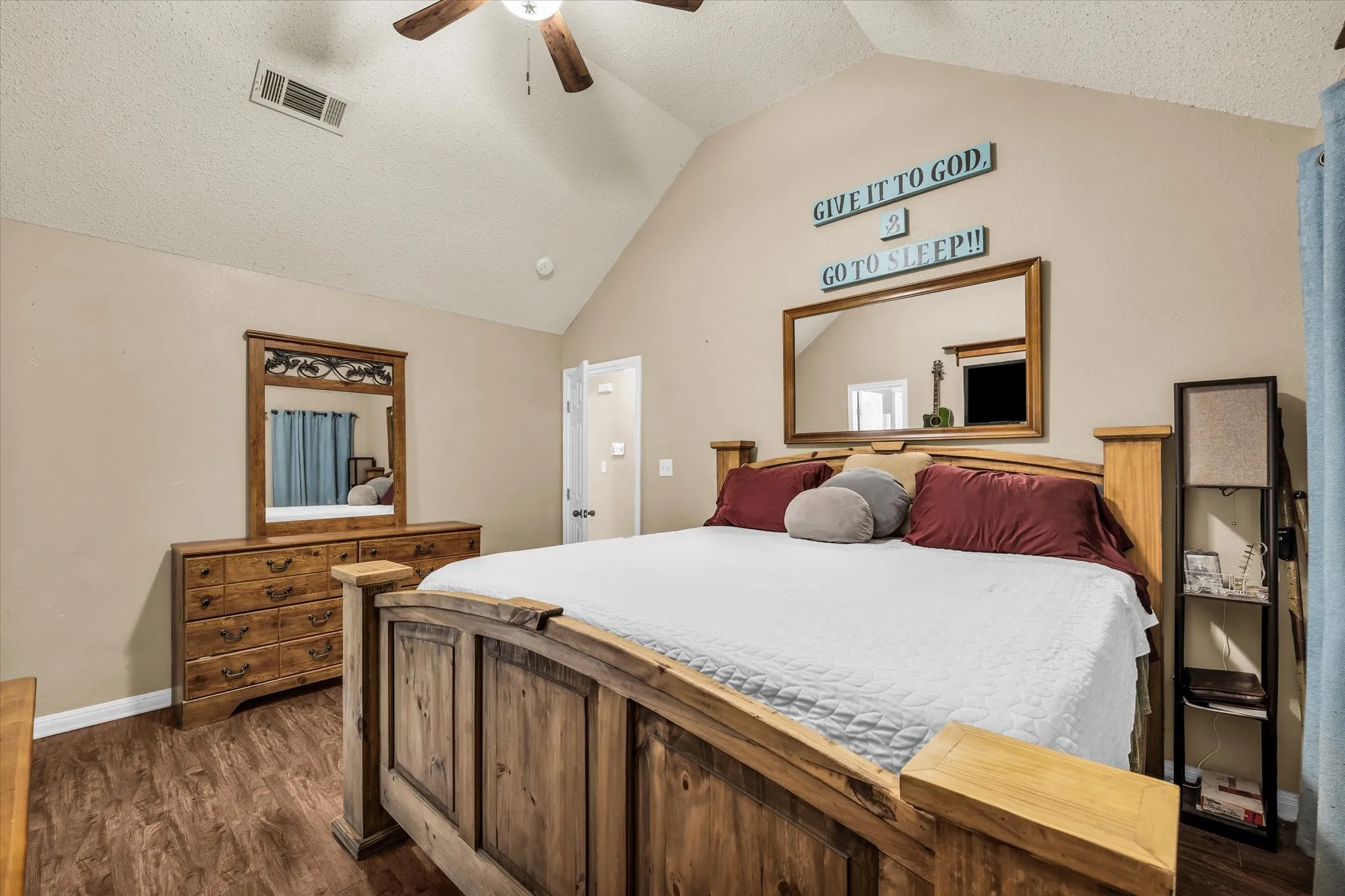 Vaulted ceiling, wood-finish flooring, ceiling fan, and painted walls
