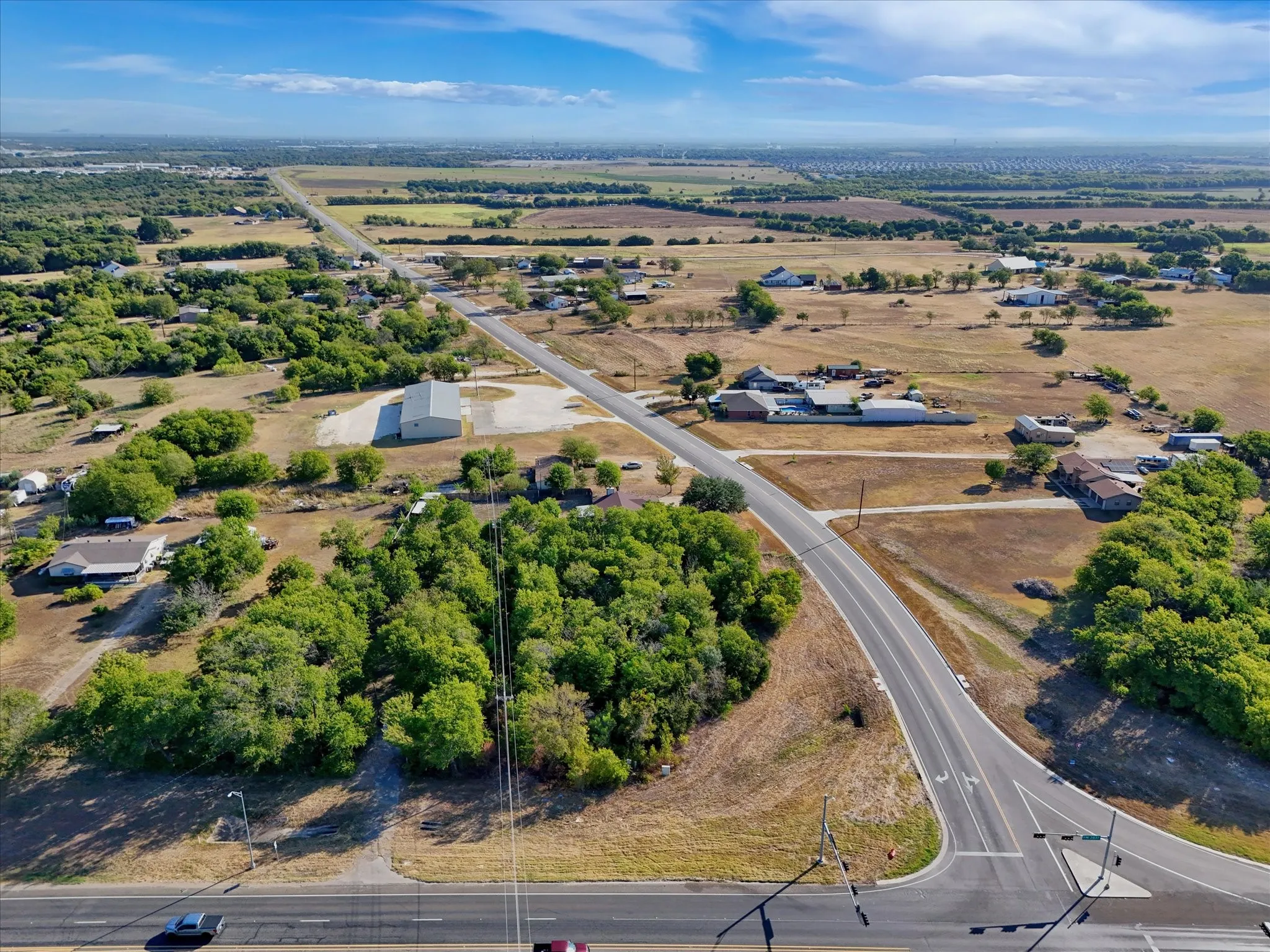 Expansive land parcel featuring existing roadways and mature trees