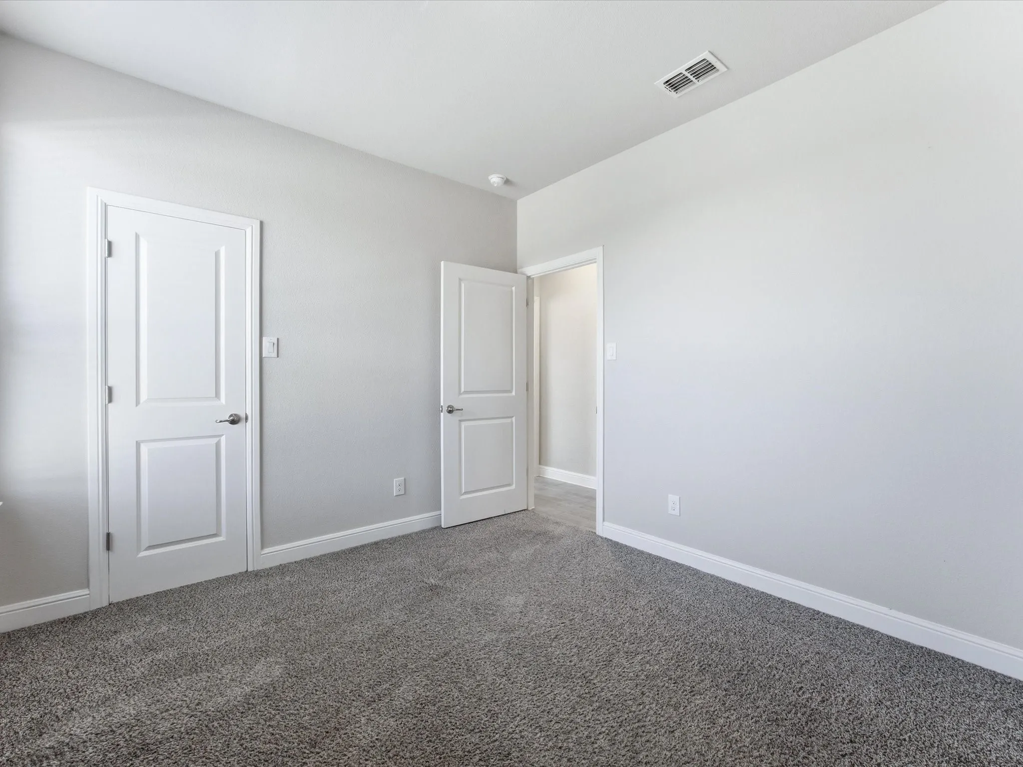 Gray textured carpeting and light gray wall paint