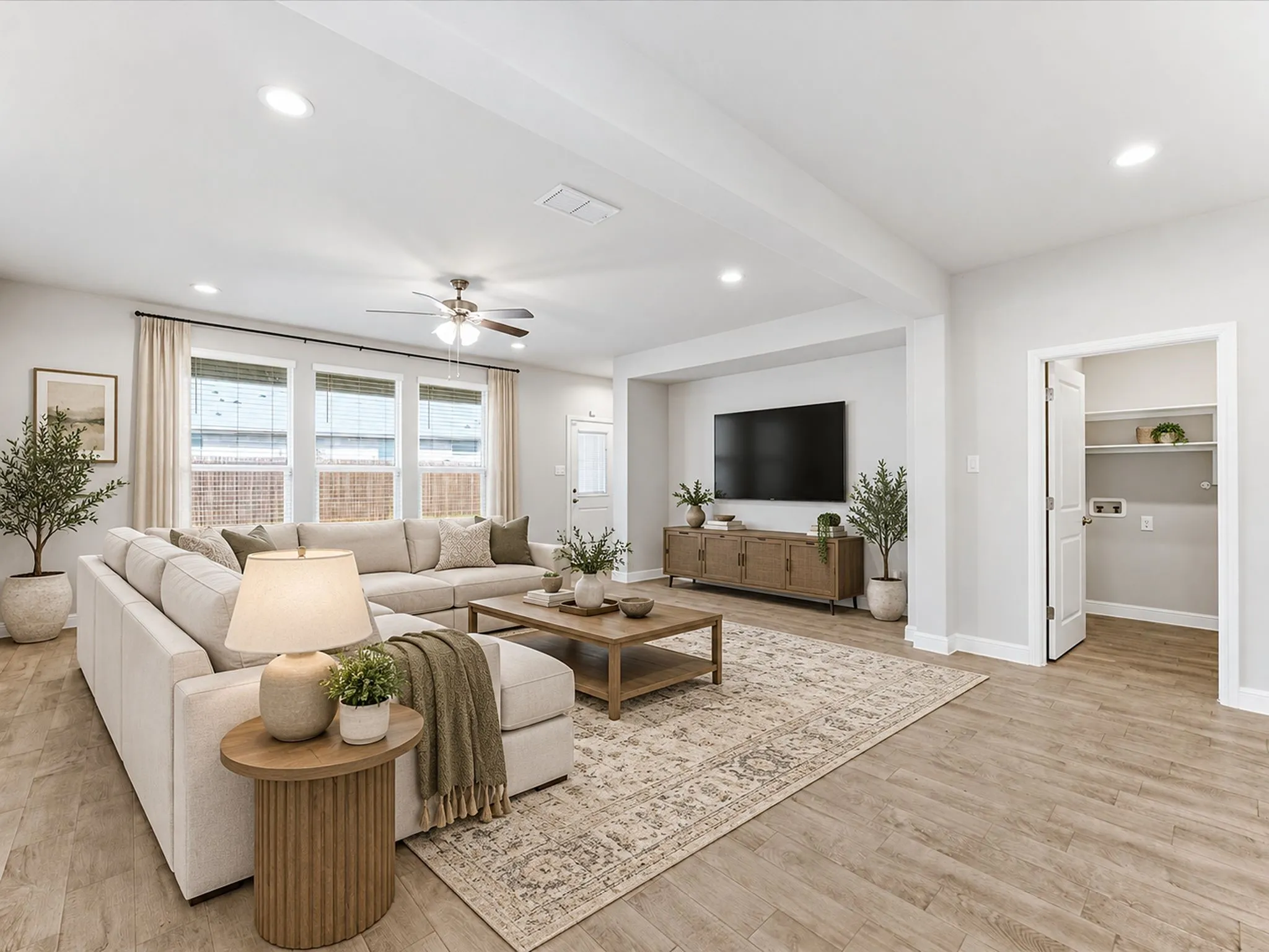 Recessed lighting throughout, ceiling fan, multiple windows with blinds, wood-finish flooring, and a laundry closet with shelving