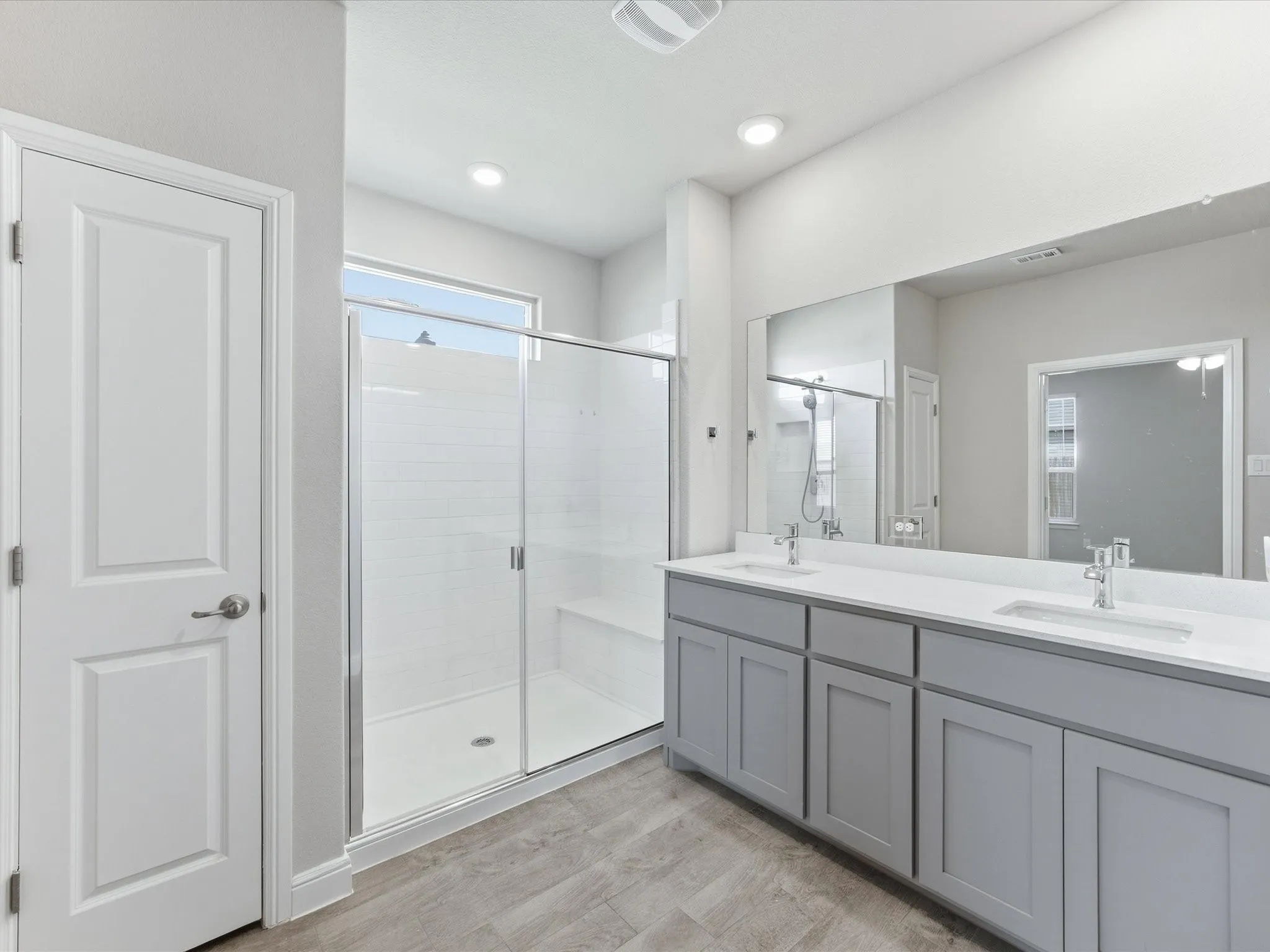 Dual vanity with gray cabinetry, white countertops, and undermount sinks