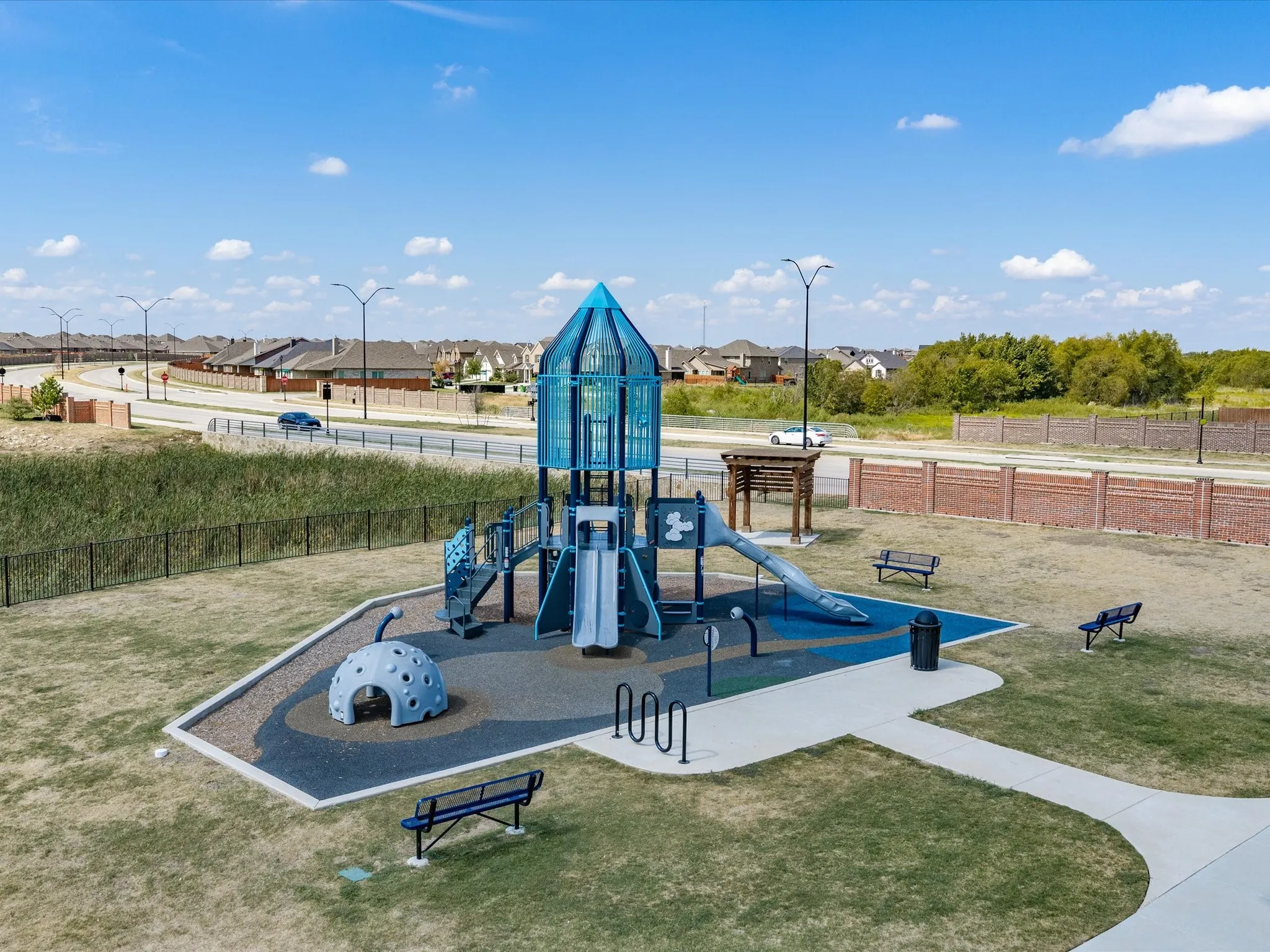 Playground area featuring a rocket-themed play structure, multiple slides, and a gray domed climber