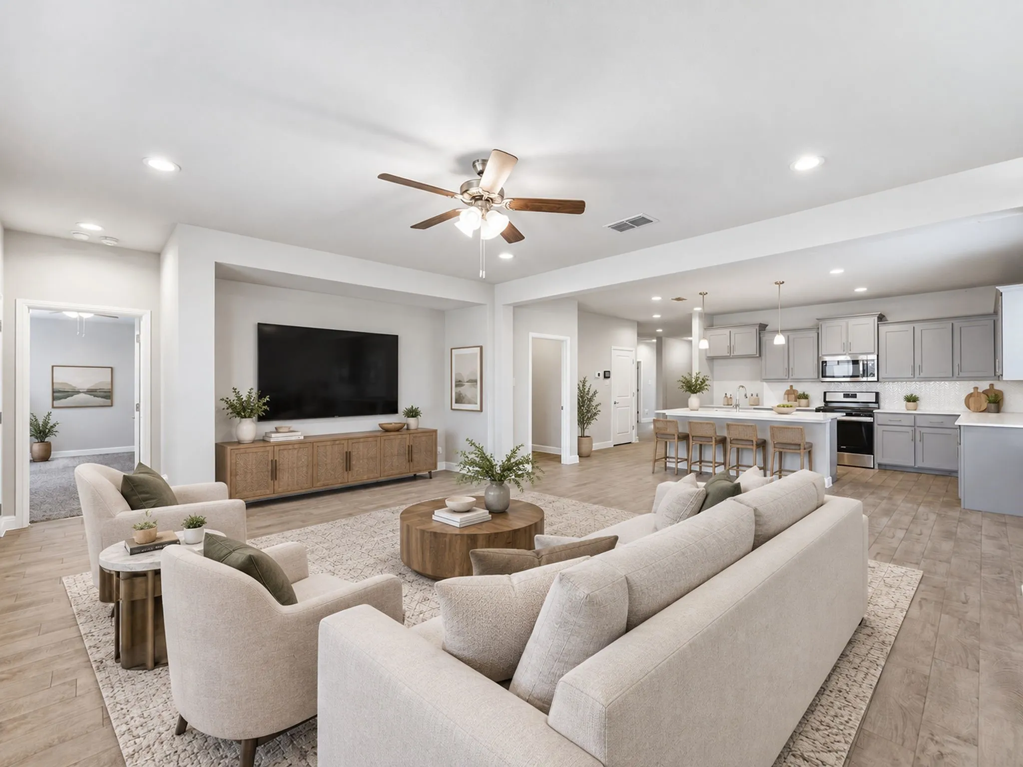 Open-concept living space featuring wood-finish flooring, recessed lighting, and a ceiling fan
