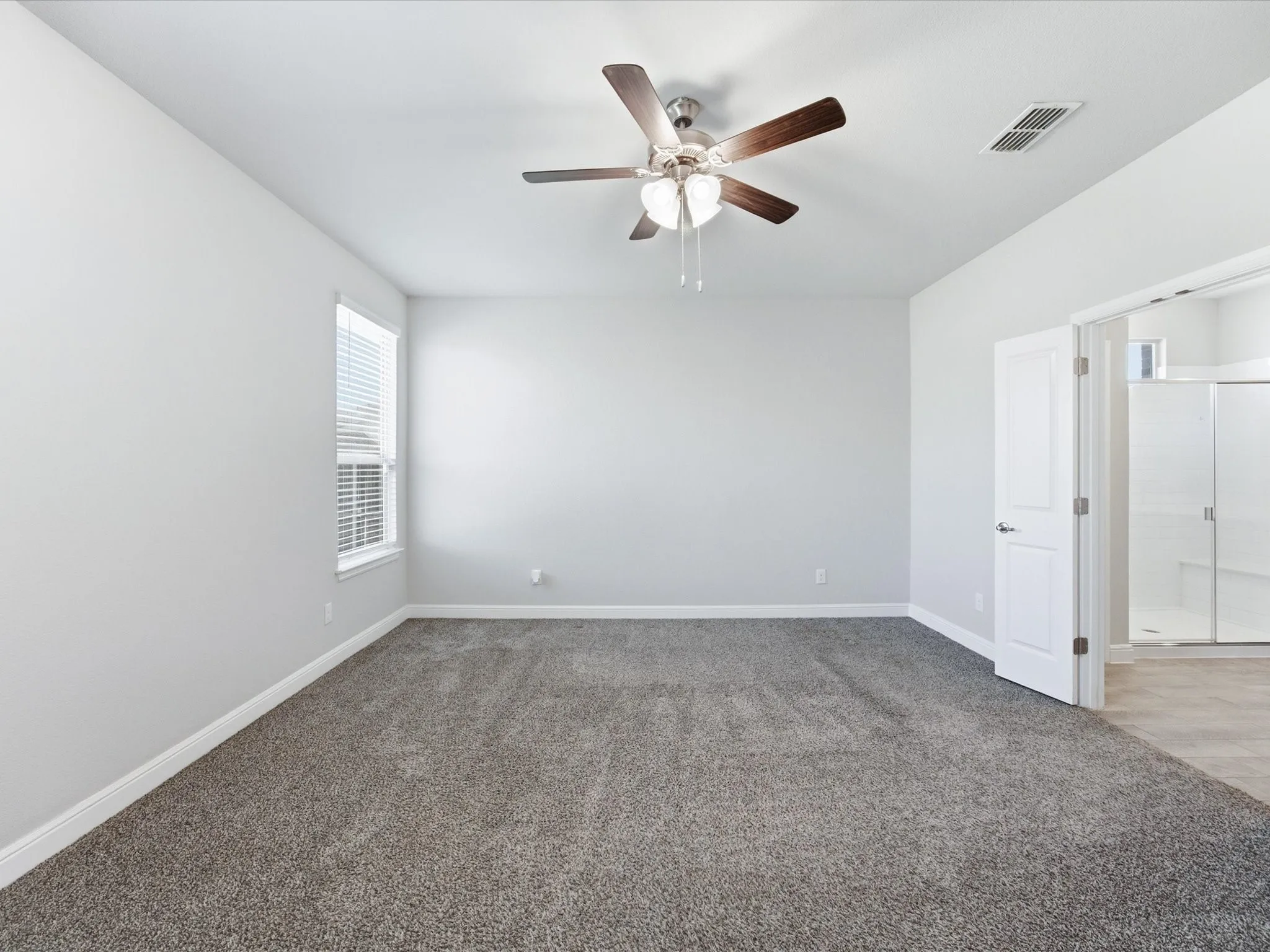Expansive room with neutral carpet flooring and white walls