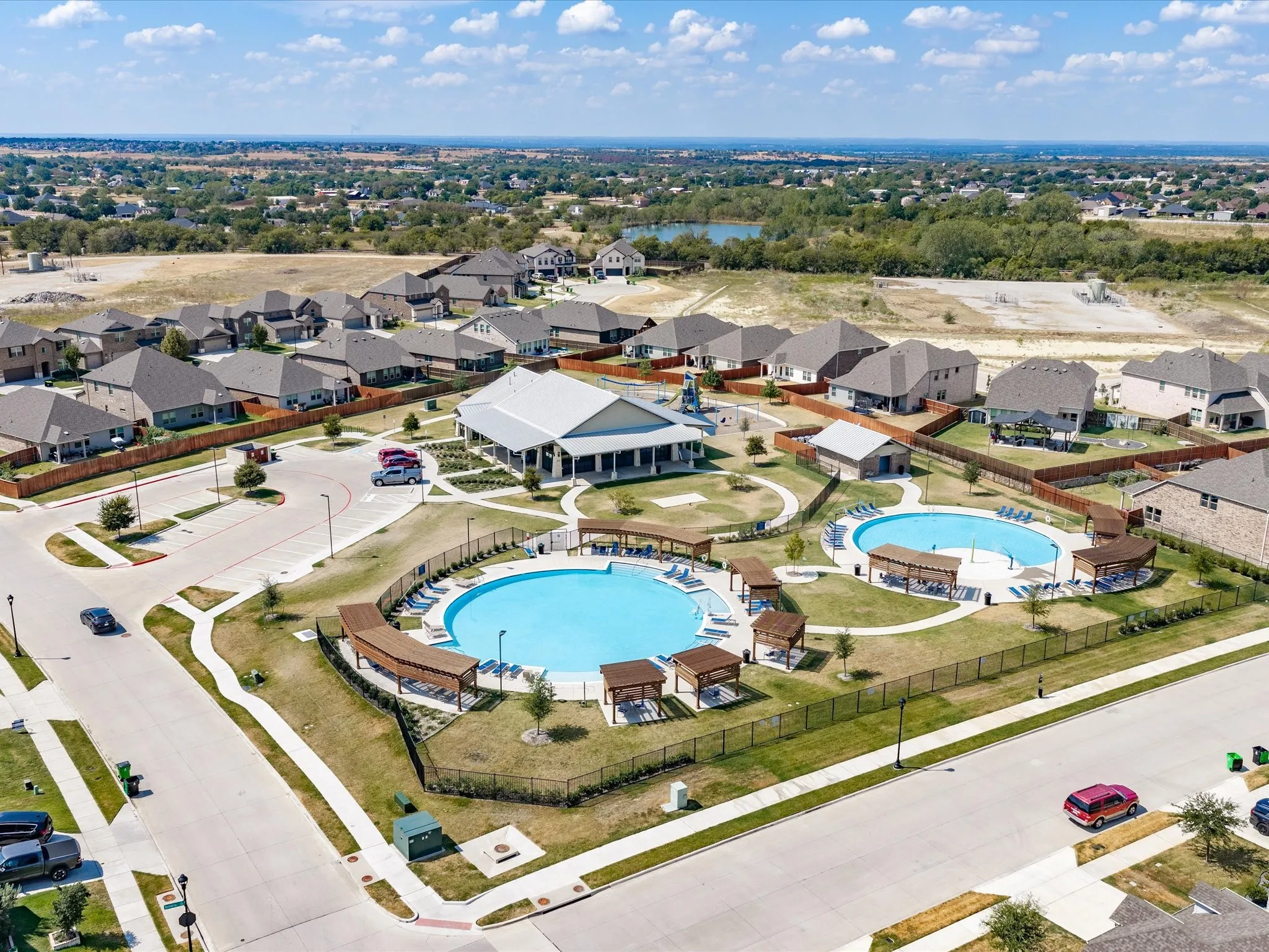 Community recreation center featuring two pools, a playground, and a central gathering building