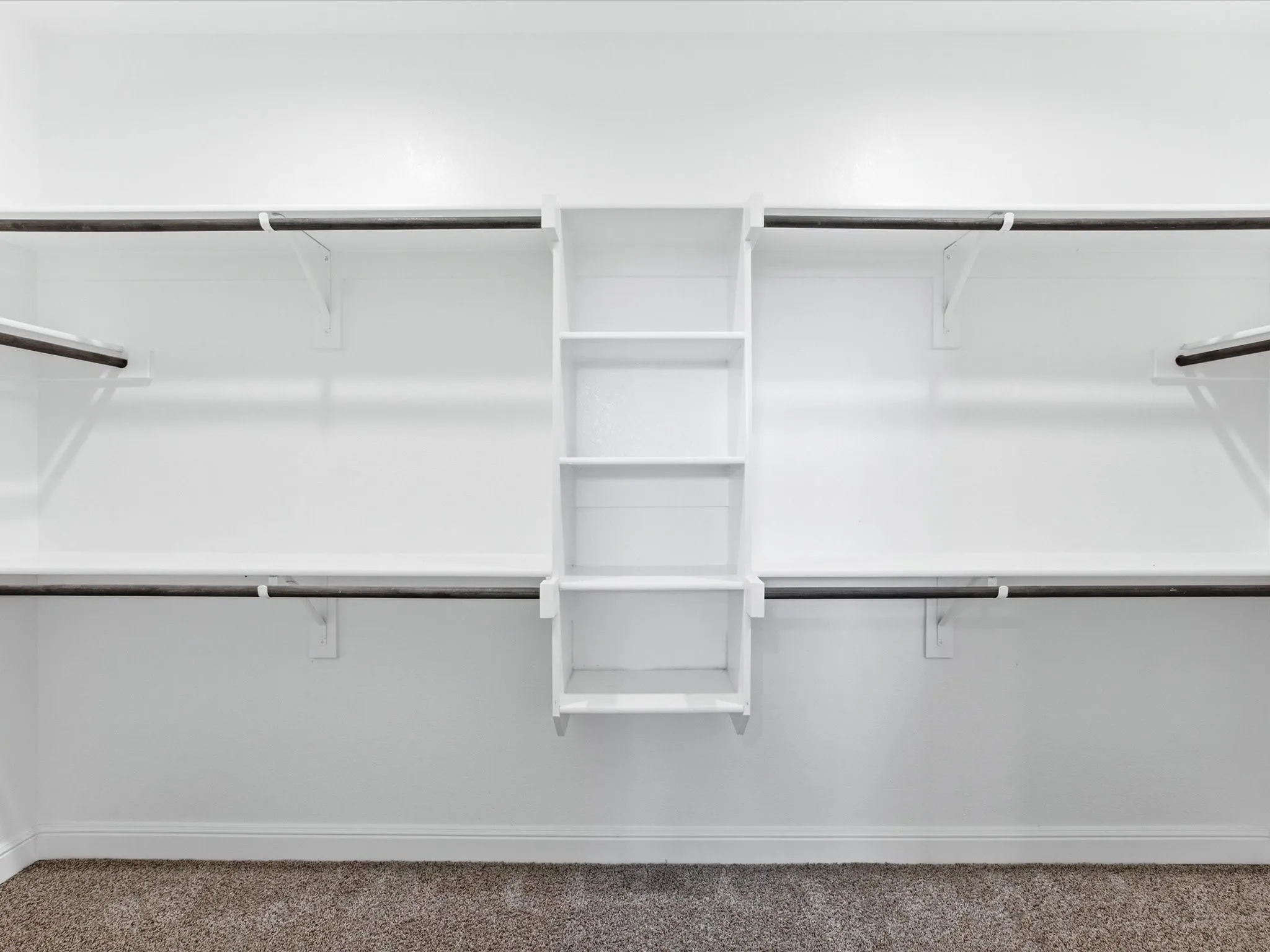 Built-in closet shelving system with multiple hanging rods and integrated vertical storage