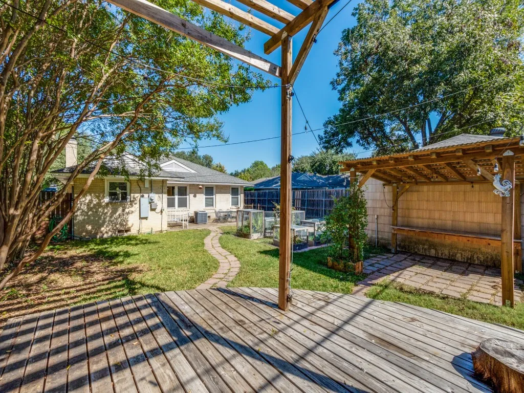 Wooden terrace with a patio, a fenced backyard, and a pergola