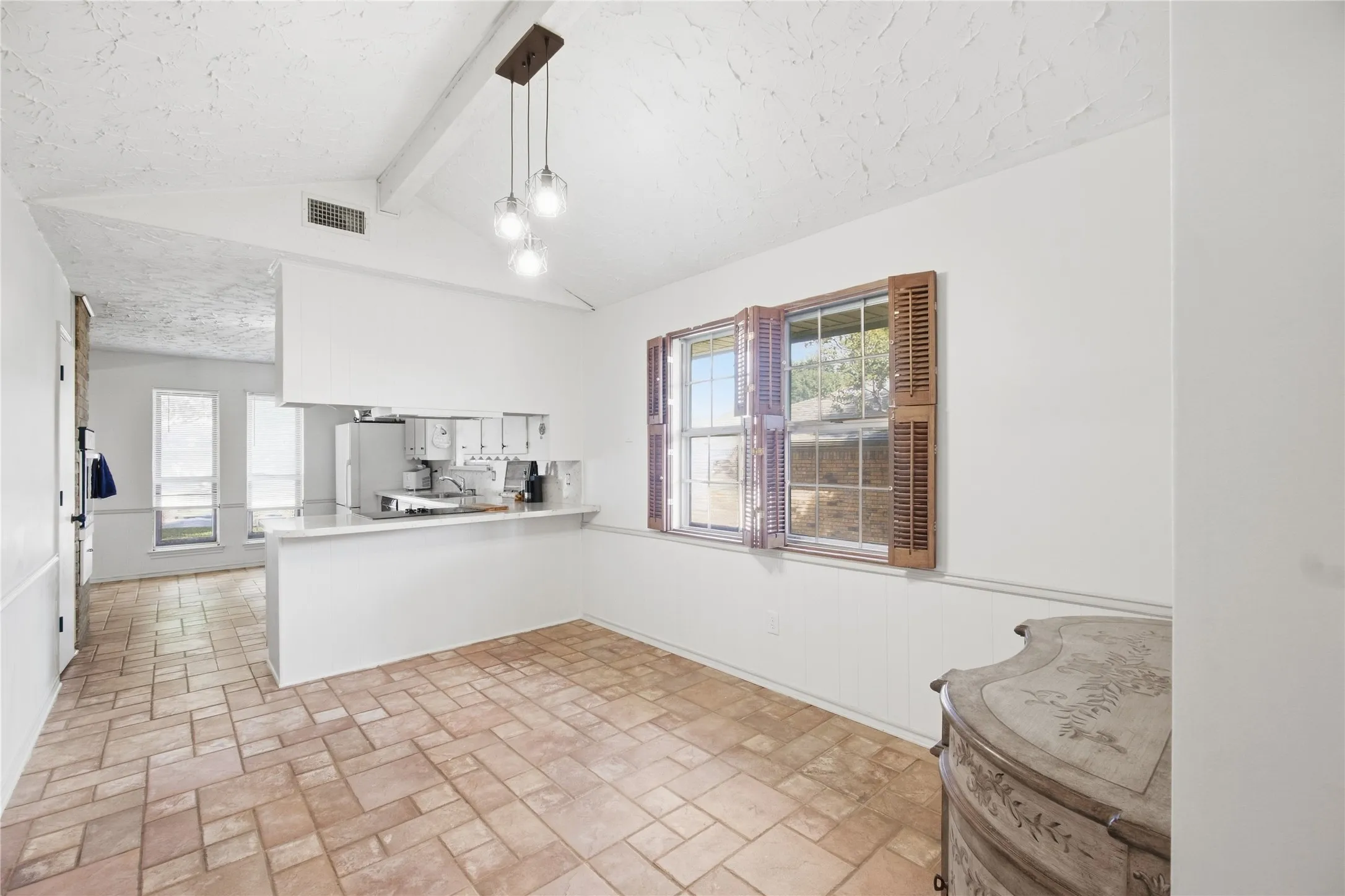 Open concept dining area with tile flooring and a vaulted ceiling
