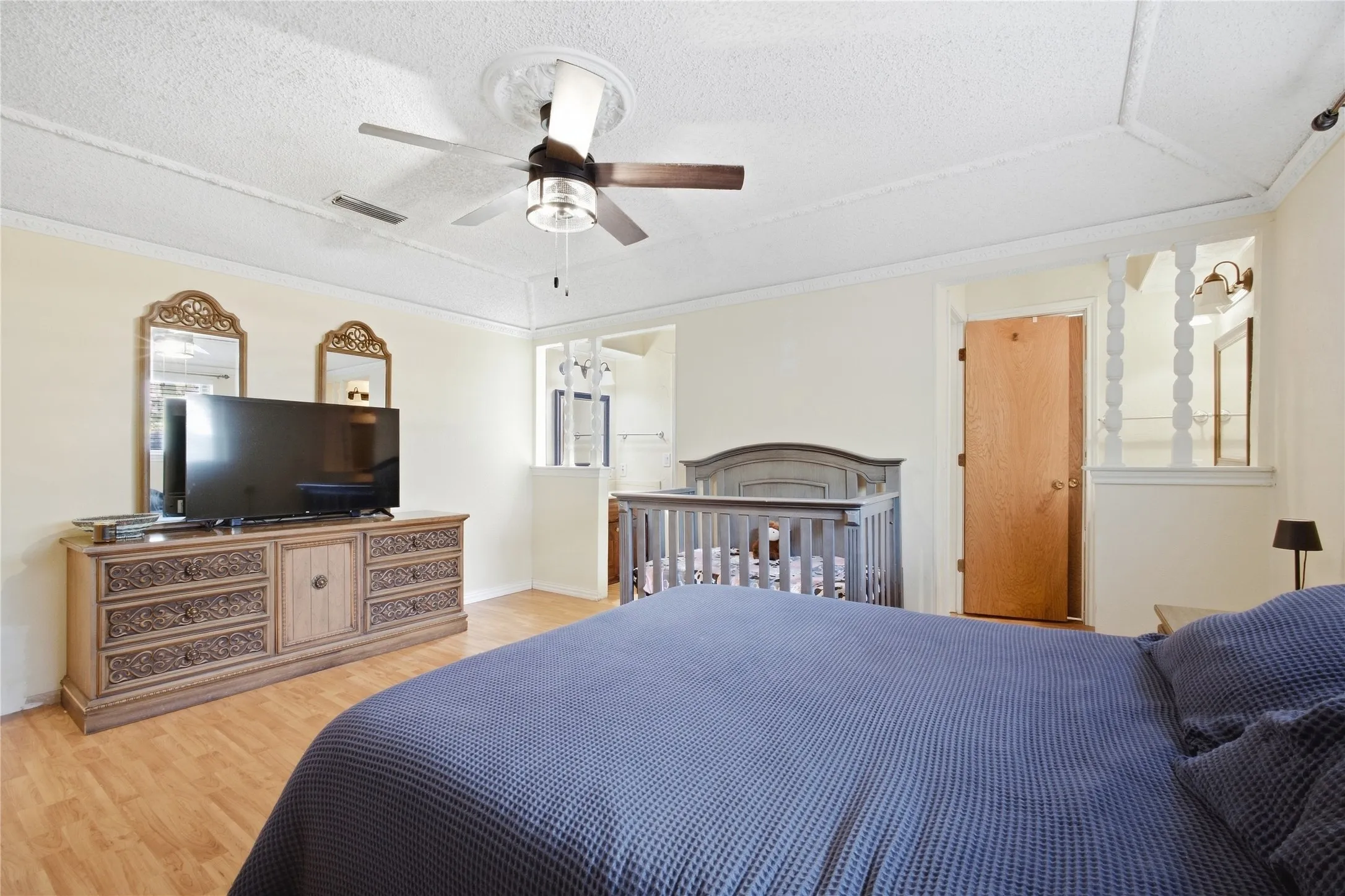Wood-finish flooring with a ceiling fan featuring a decorative medallion