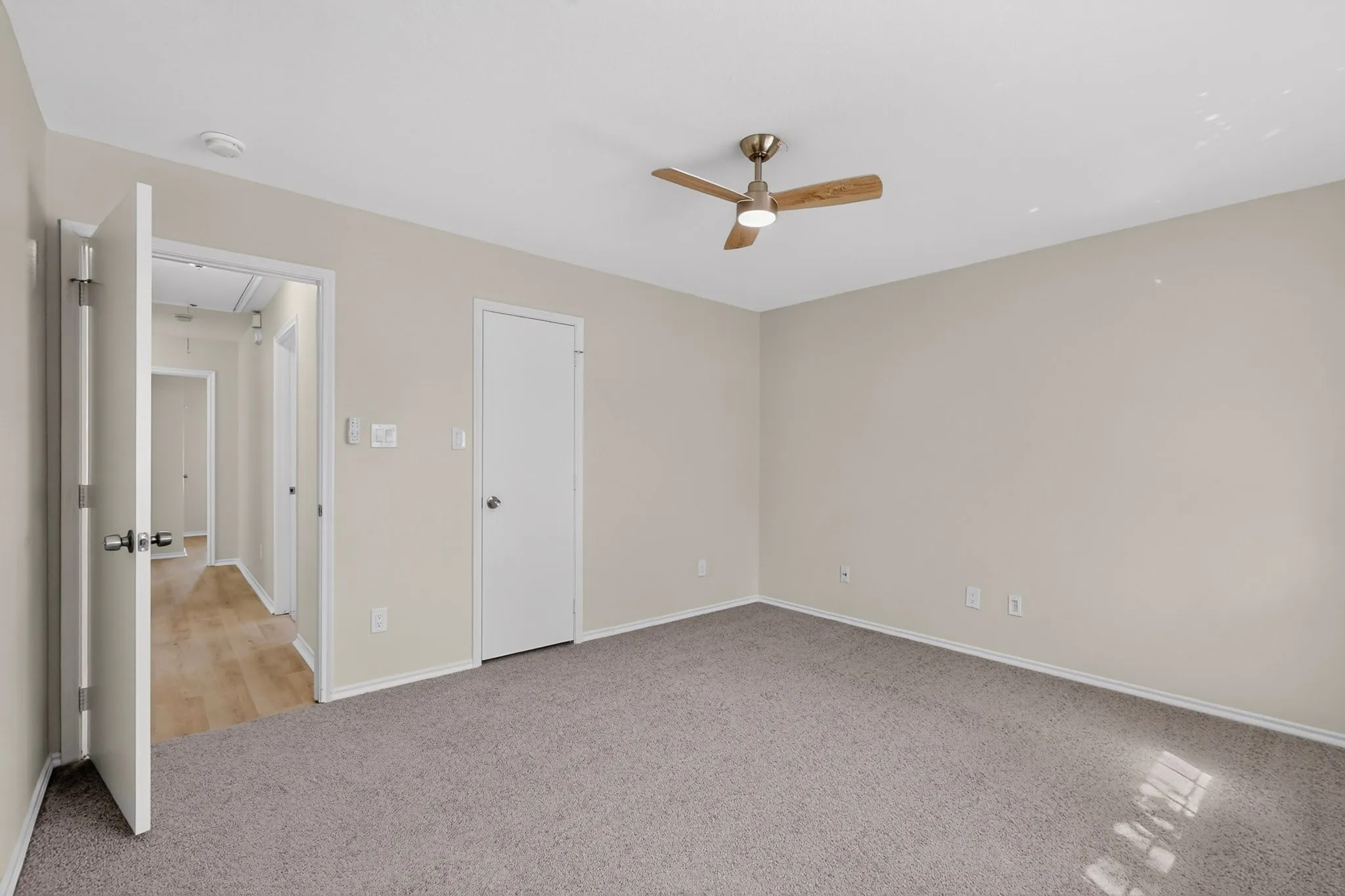Spacious room featuring neutral carpet flooring and light-toned wall paint