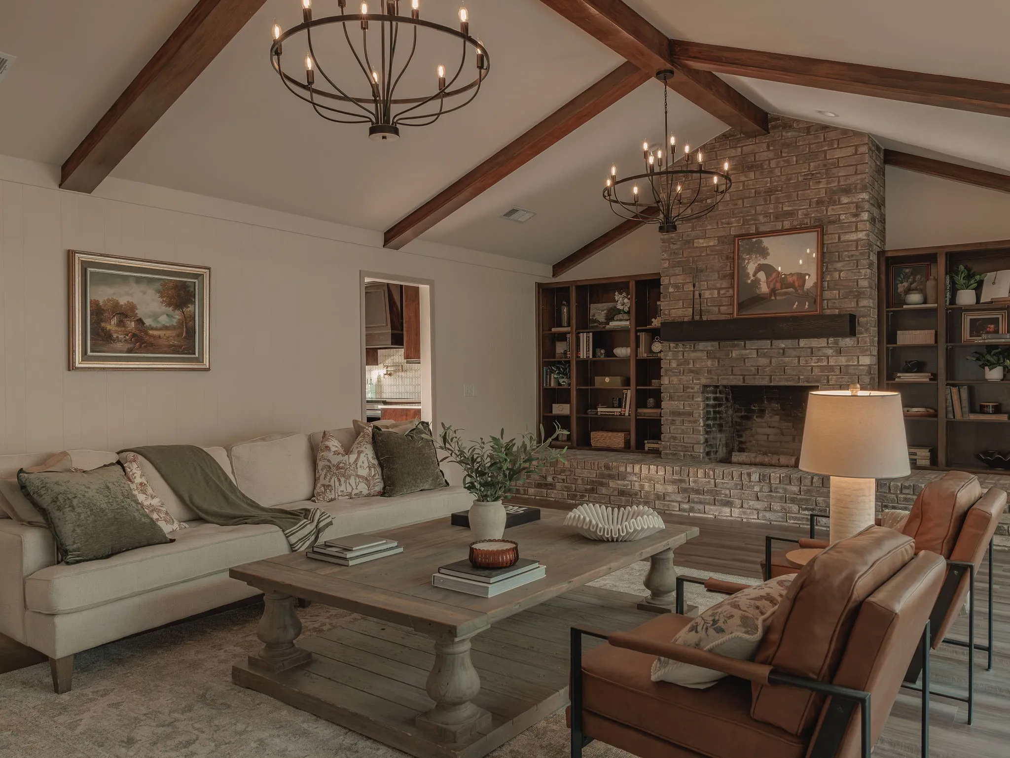 Vaulted ceilings, exposed wood beams and the original brick fireplace give the living room a strong sense of character and architectural depth.