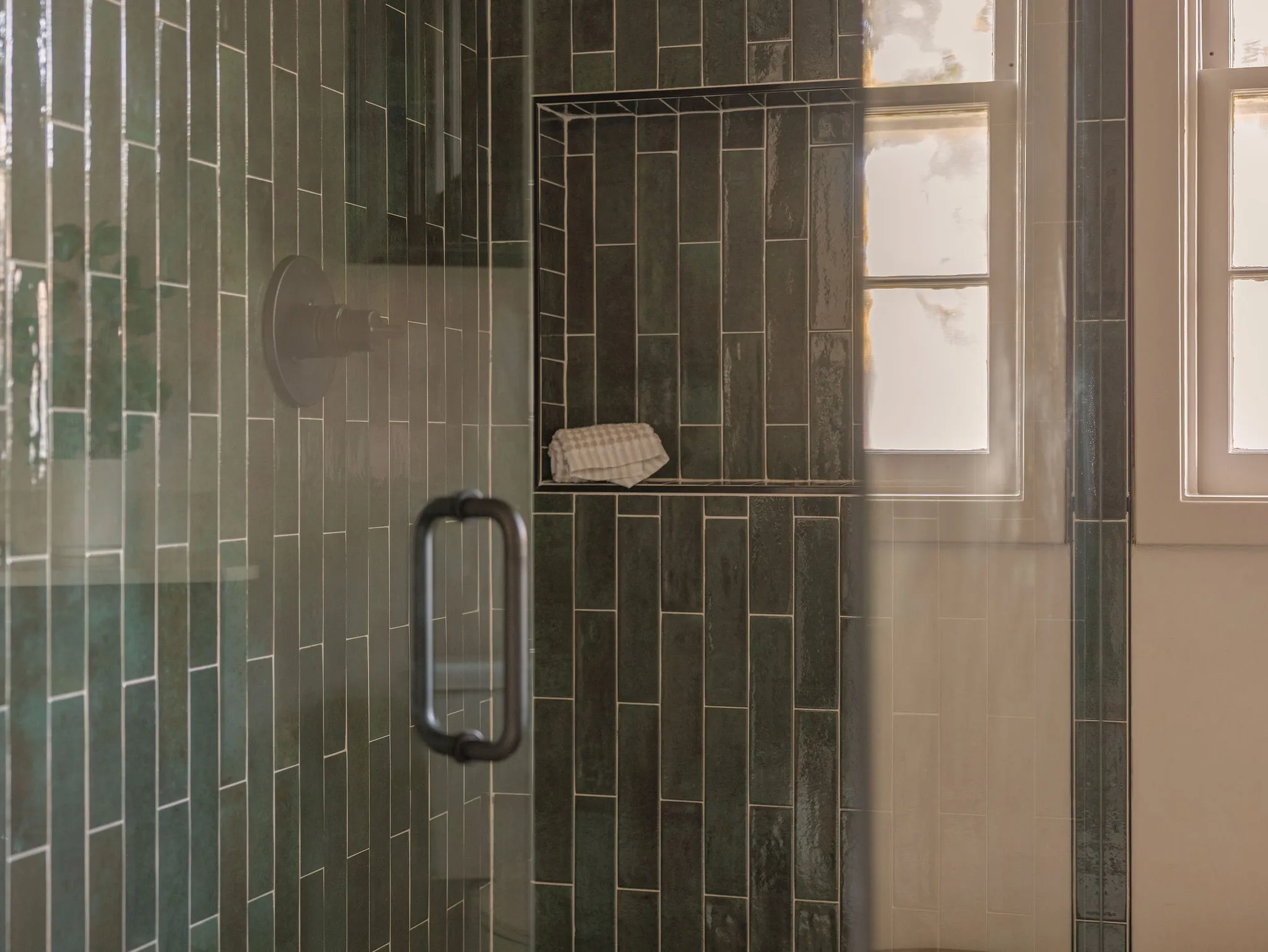 A floor to ceiling tiled walk in shower complements the custom walnut cabinetry and softly textured Roman clay walls.