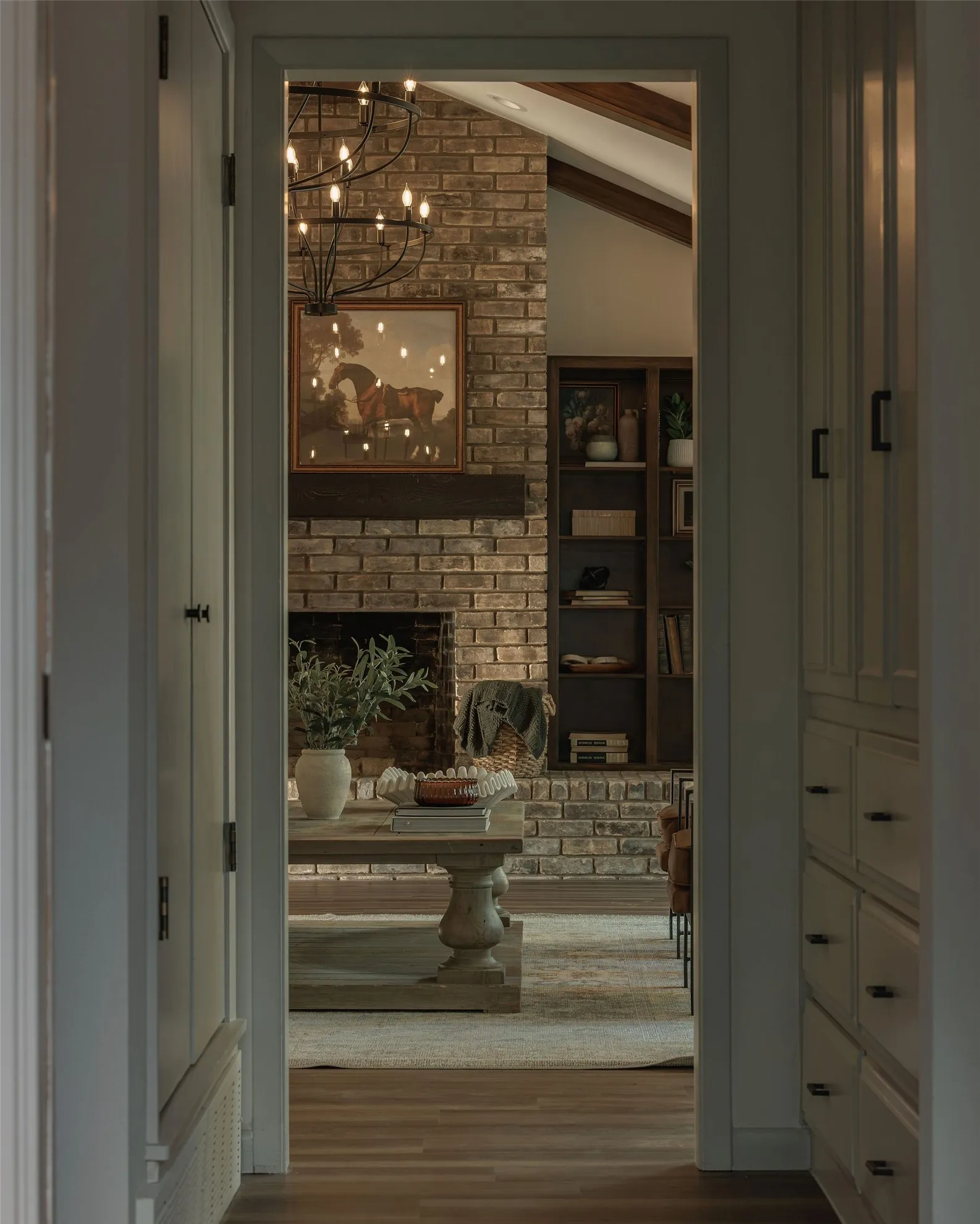 Thoughtful sightlines throughout the home frame the original brick fireplace, built in bookcases and exposed wood beams.