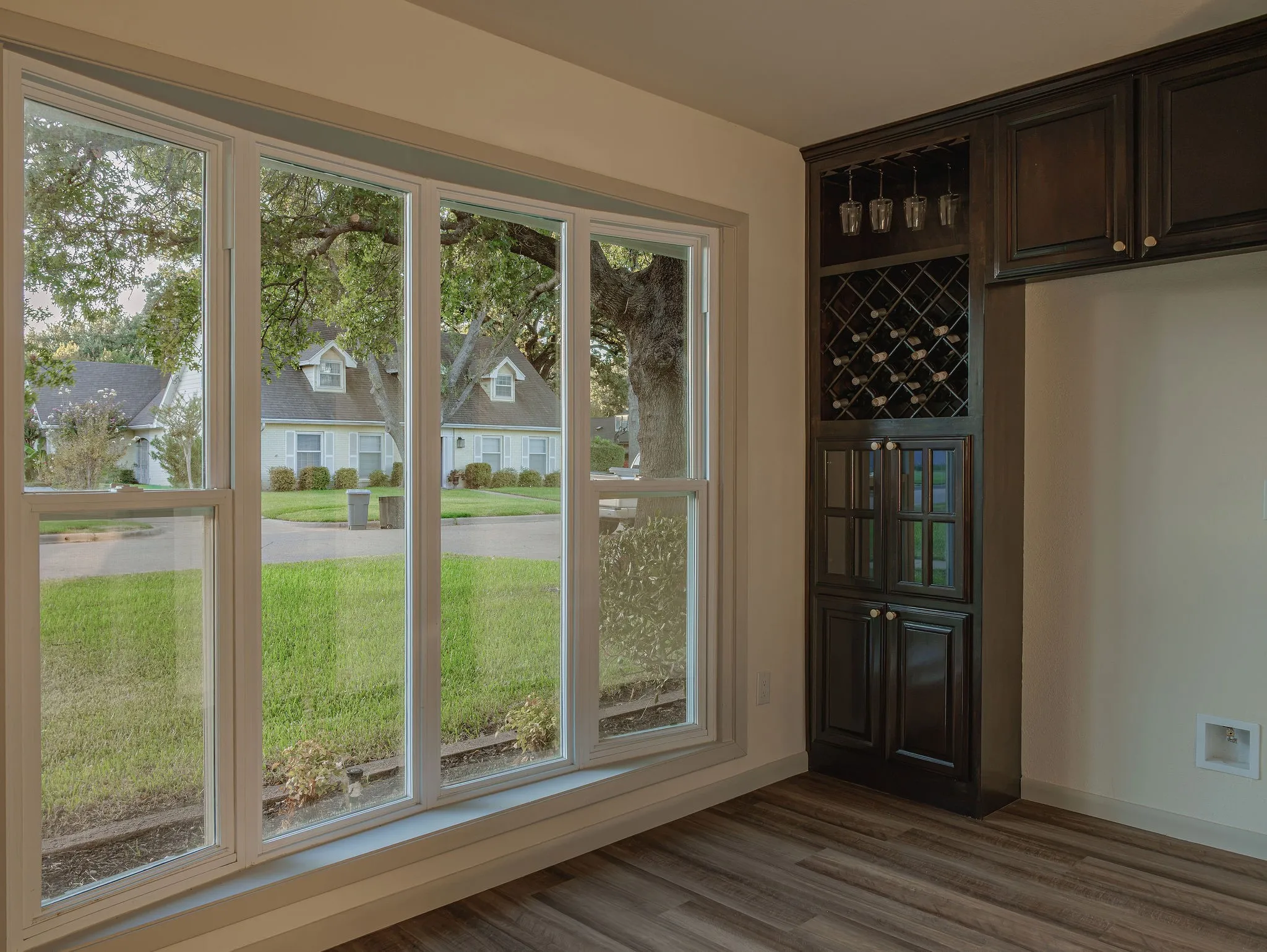 A light filled breakfast area with oversized windows and a custom built in wine bar, designed for both everyday living and entertaining.