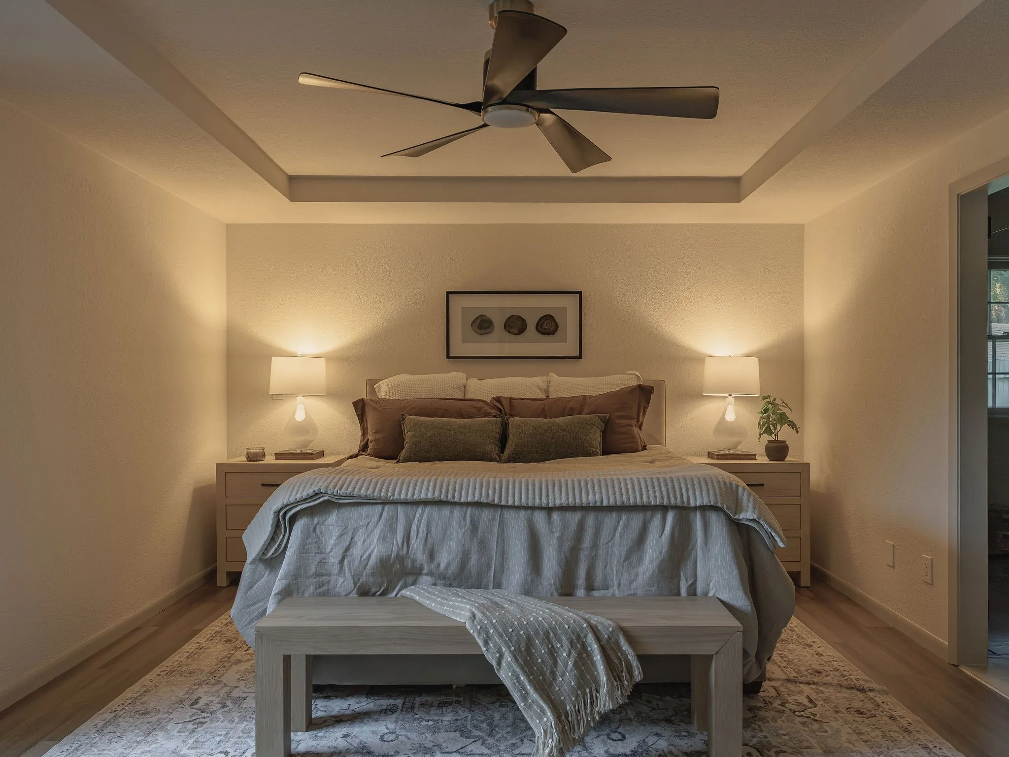 The oversized primary suite features a tray ceiling and generous proportions, creating a quiet retreat within the home.